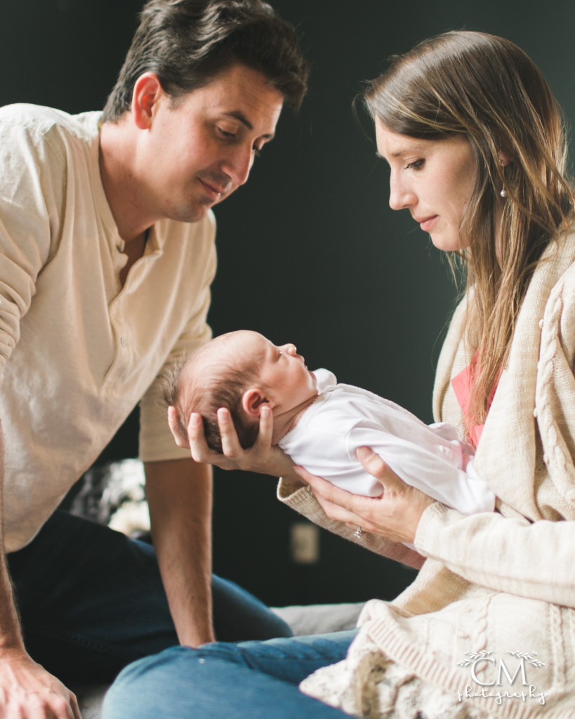 glowing new parents with sleeping newborn baby