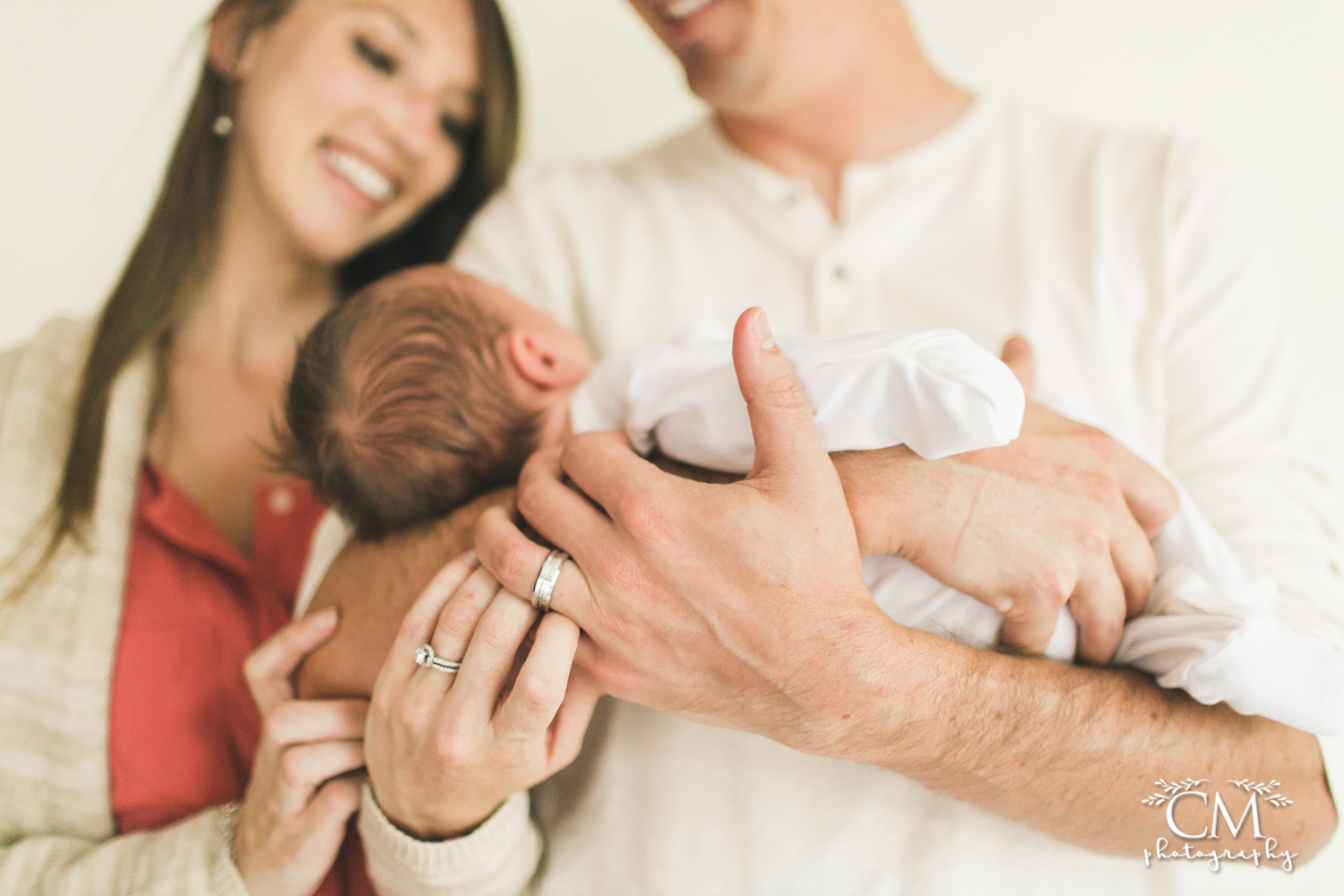 newborn baby with wedding rings