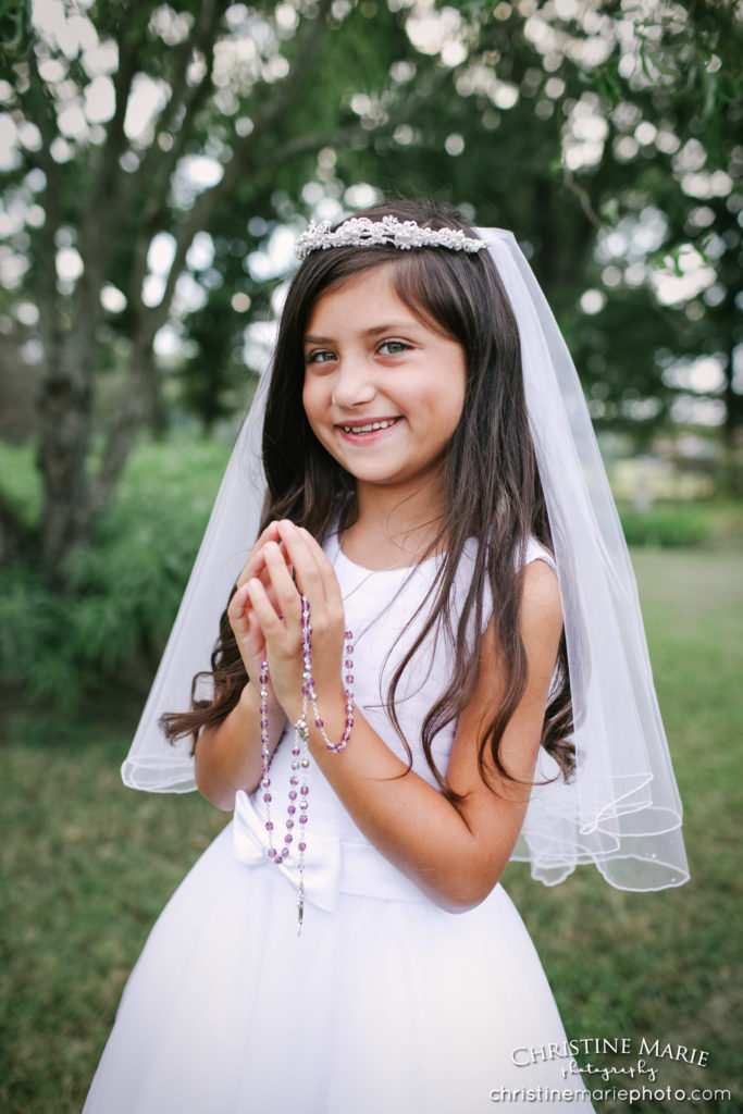 little girl holding rosary for first holy communion 