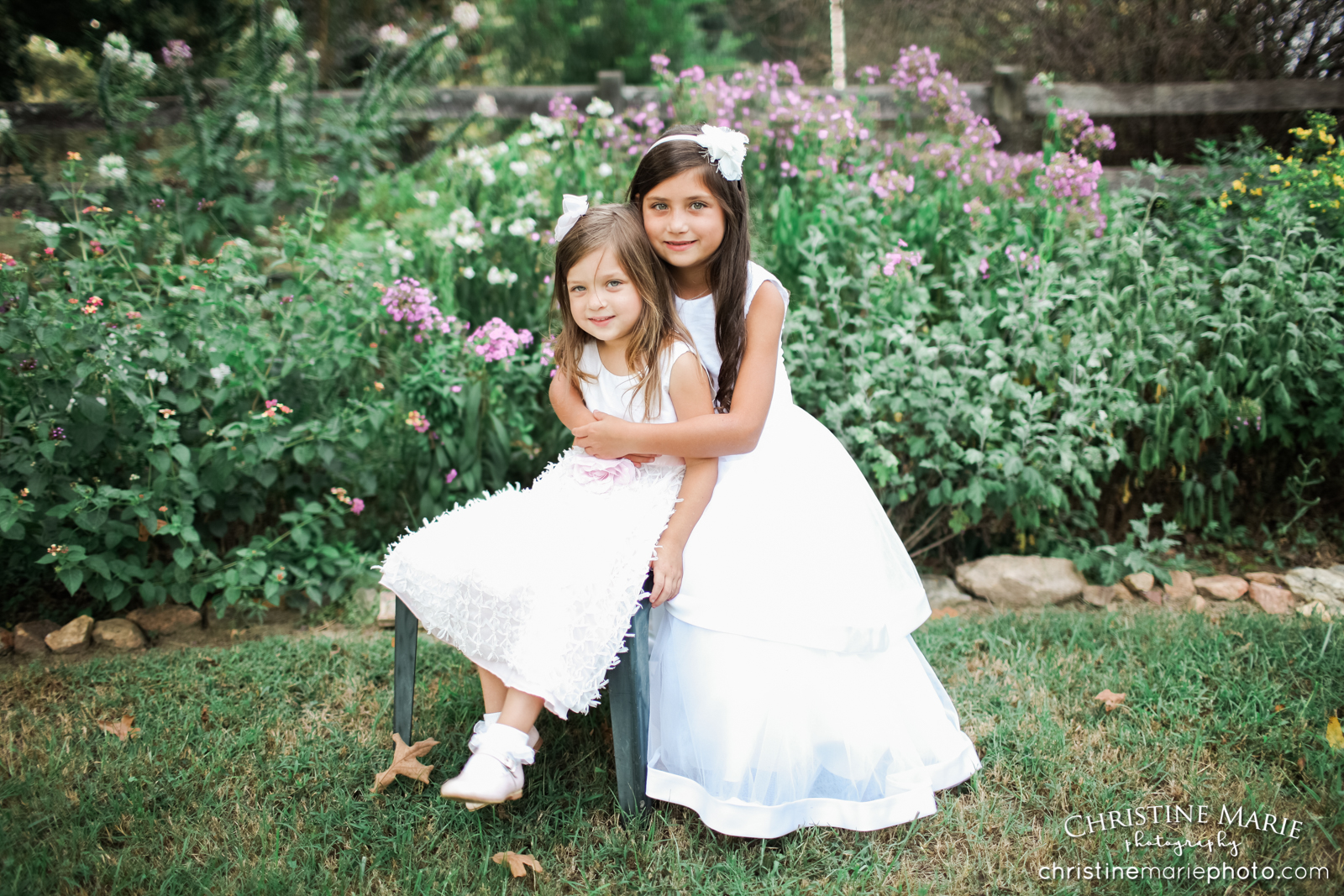 whimsical sisters portrait in flower garden and white dresses 