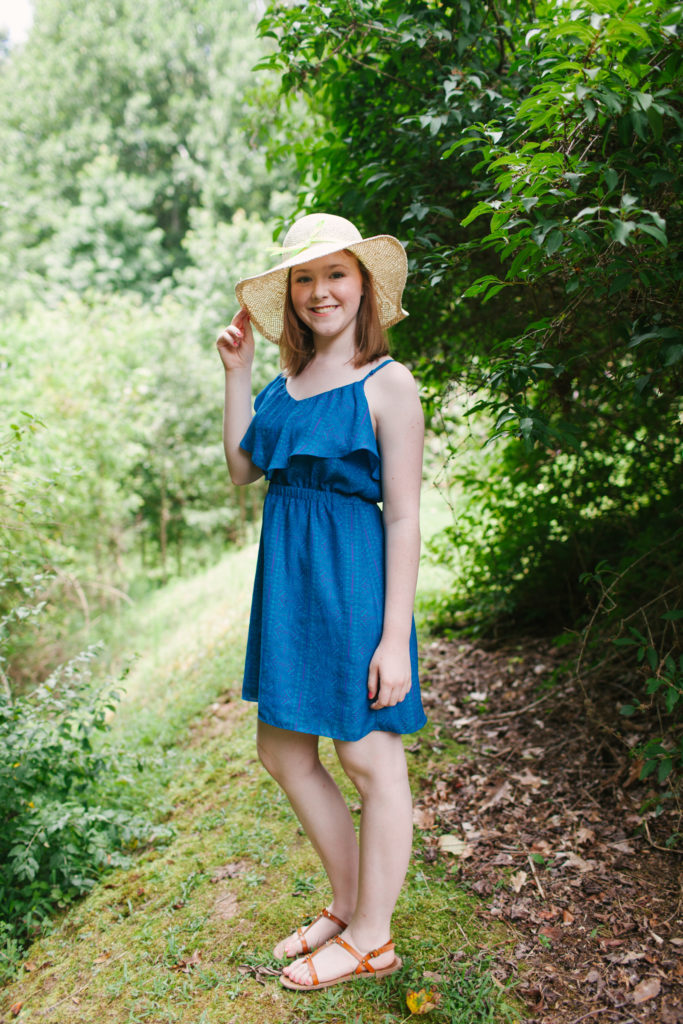 teenage girl in blue dress and floppy hat 