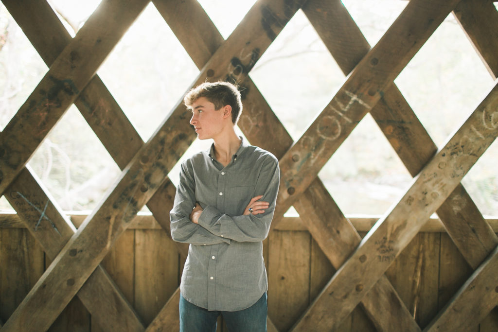 teenage boy senior photos in a bridge 