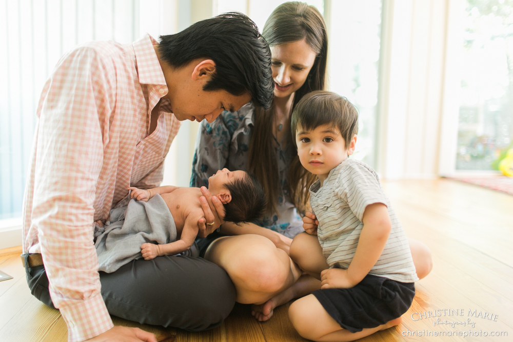 happy family admiring newborn baby boy