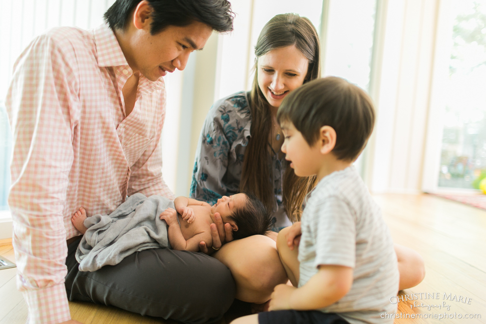 happy family of four with new baby and big brother