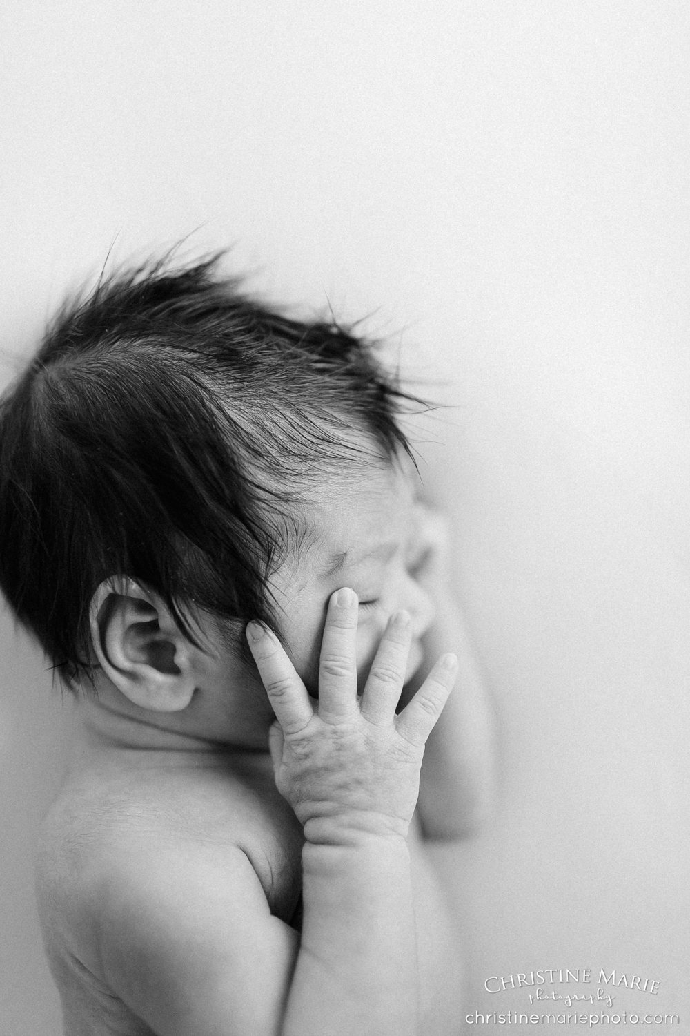 newborn baby with full head of dark hair