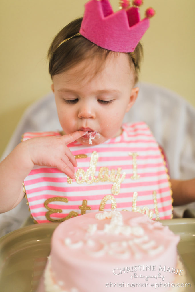 one year old girl eating birthday cake 