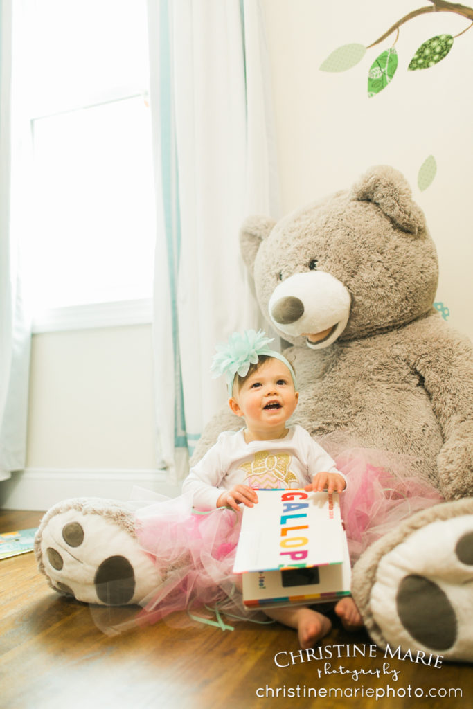 little girl in nursery with giant teddy bear 