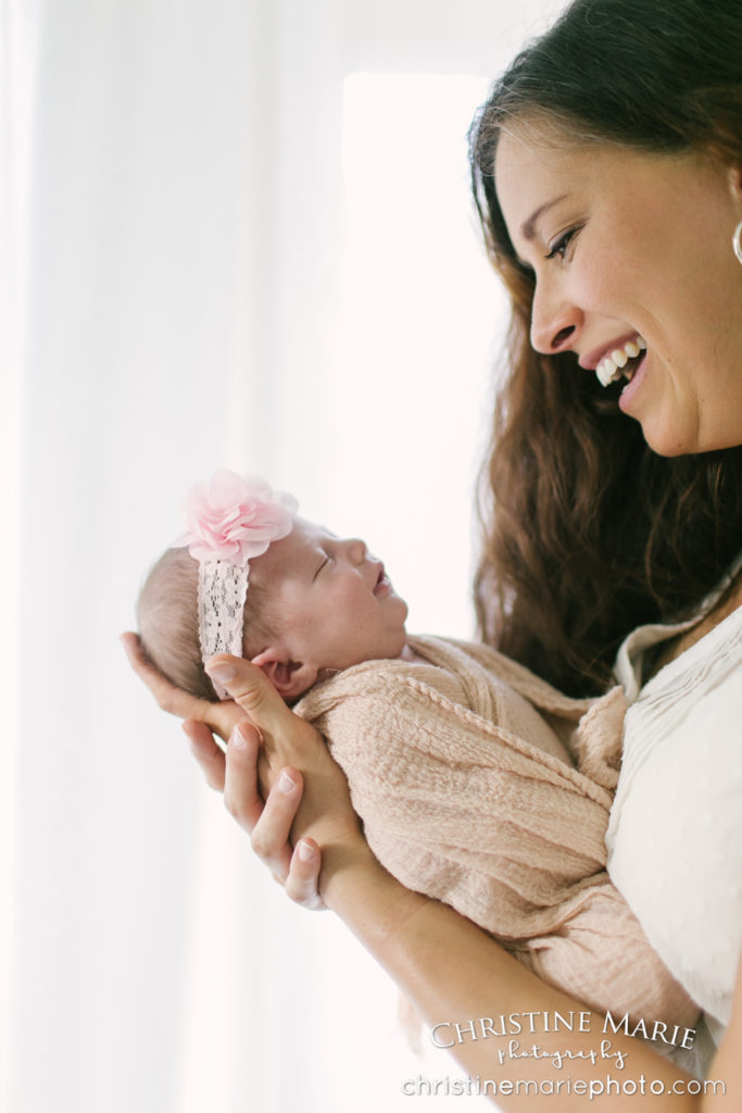 happy mother holding smiling new baby girl 