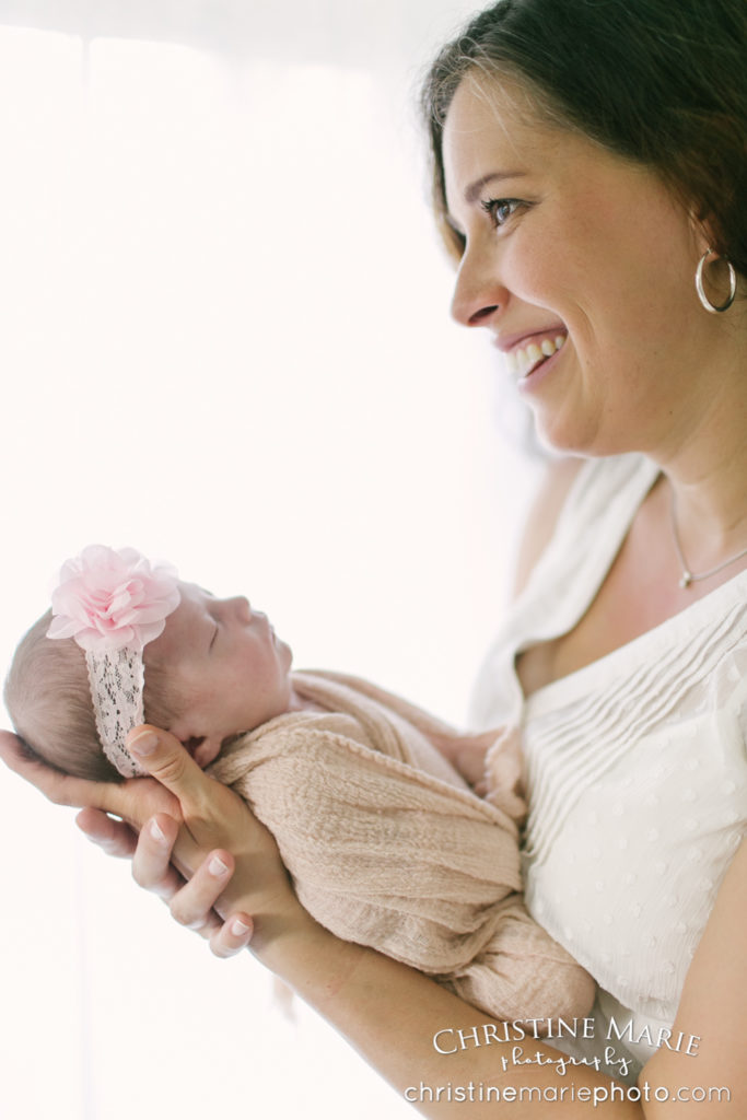 beautiful new mom holding baby girl 