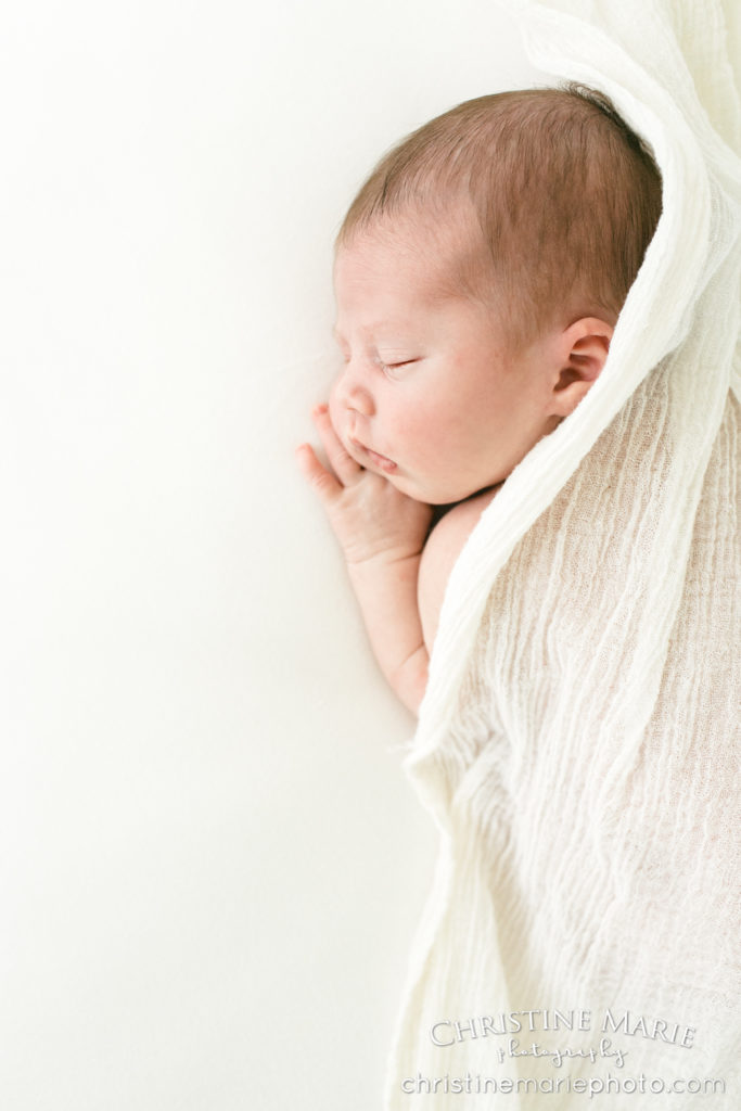 newborn baby with cream linen