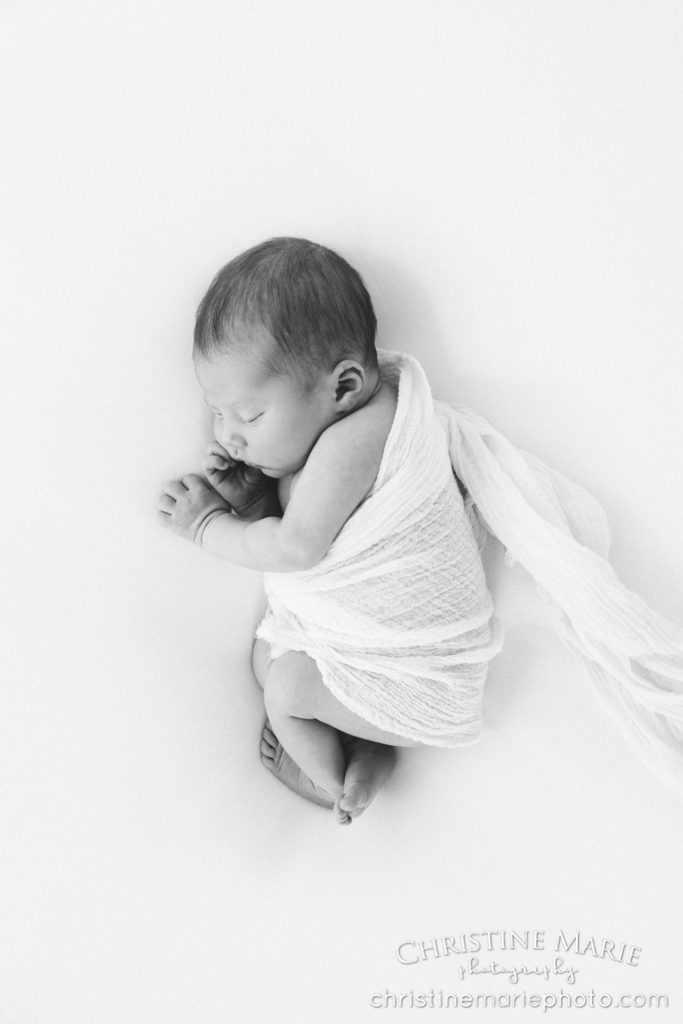 sleeping newborn wrapped in linen