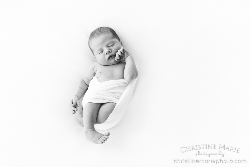 sleeping newborn baby holding foot