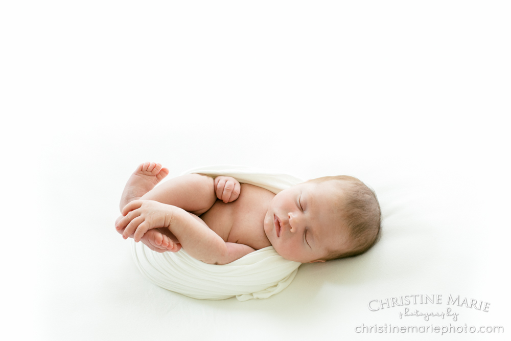 sleep newborn baby girl holding foot 