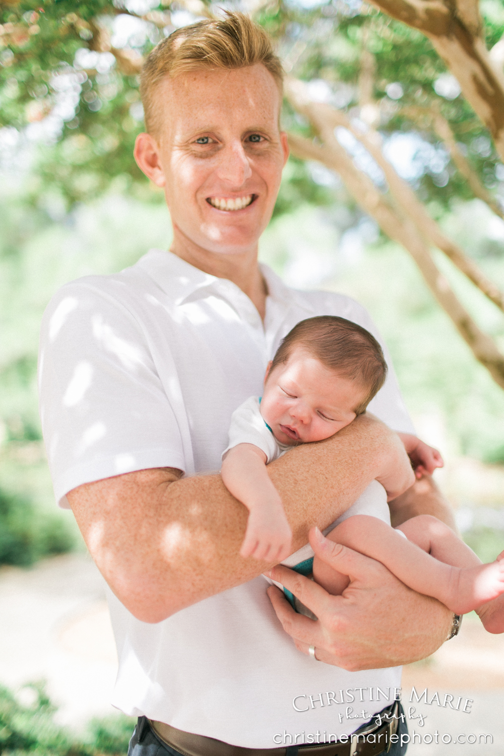 proud dad holding baby boy outside