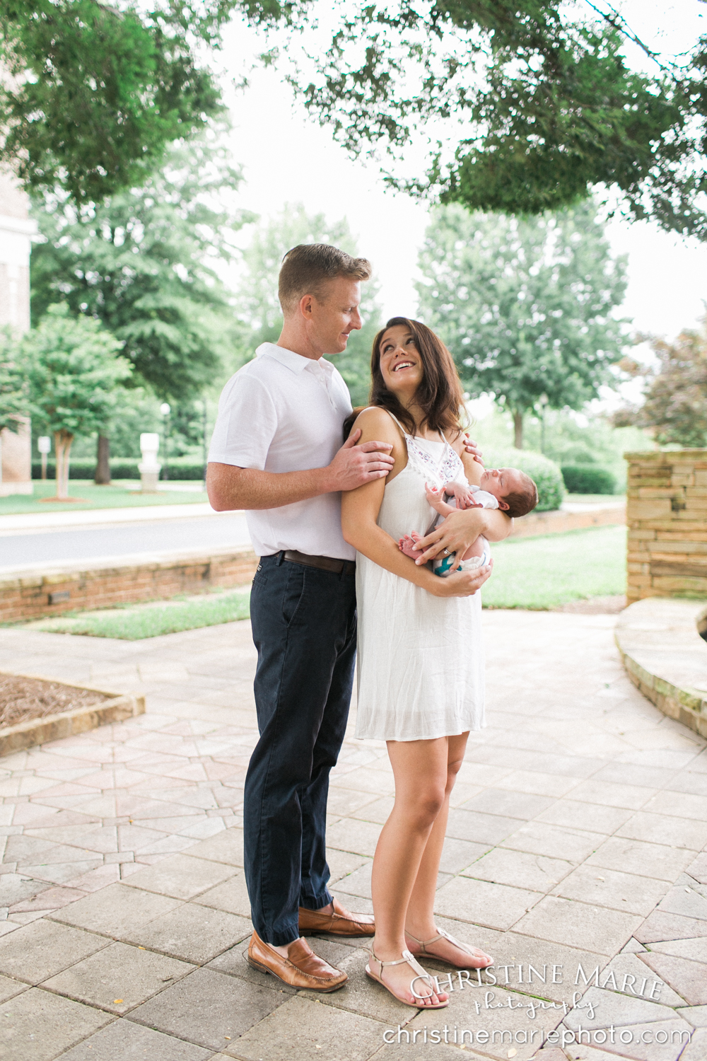 cute couple with new baby under tree