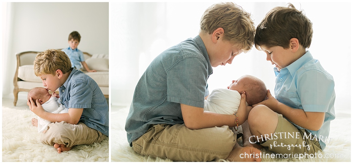 big brothers admiring newborn baby brother 