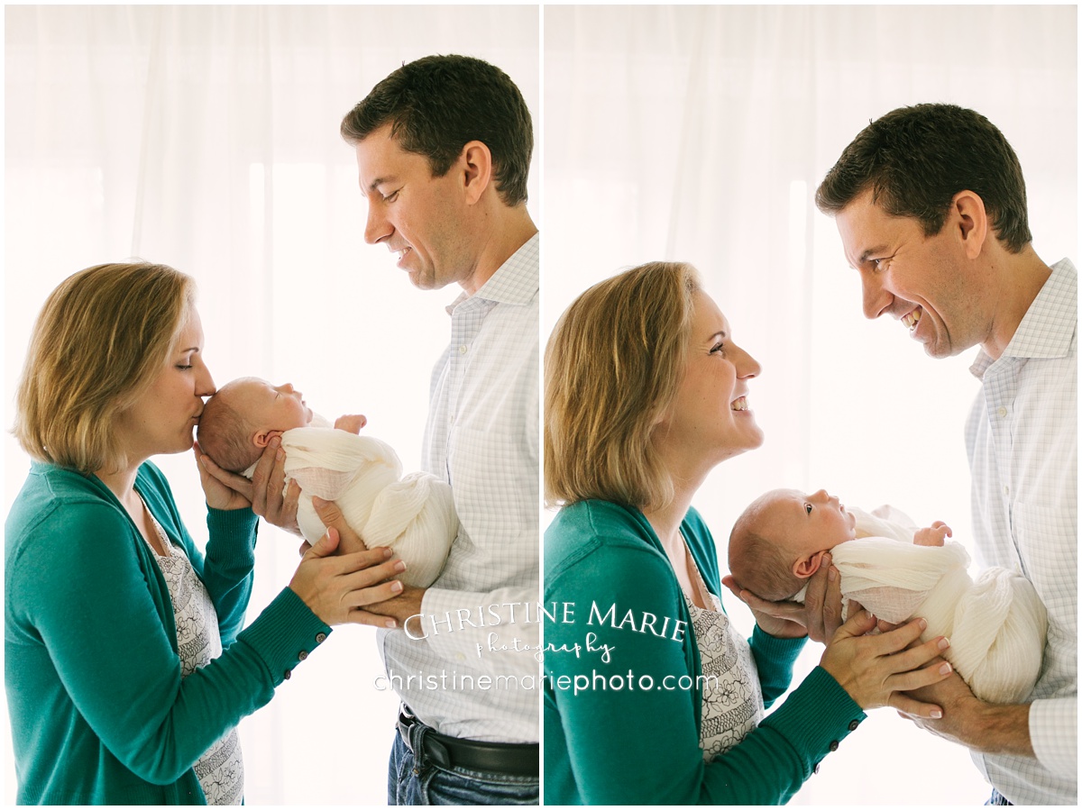 backlit happy mom and dad with newborn