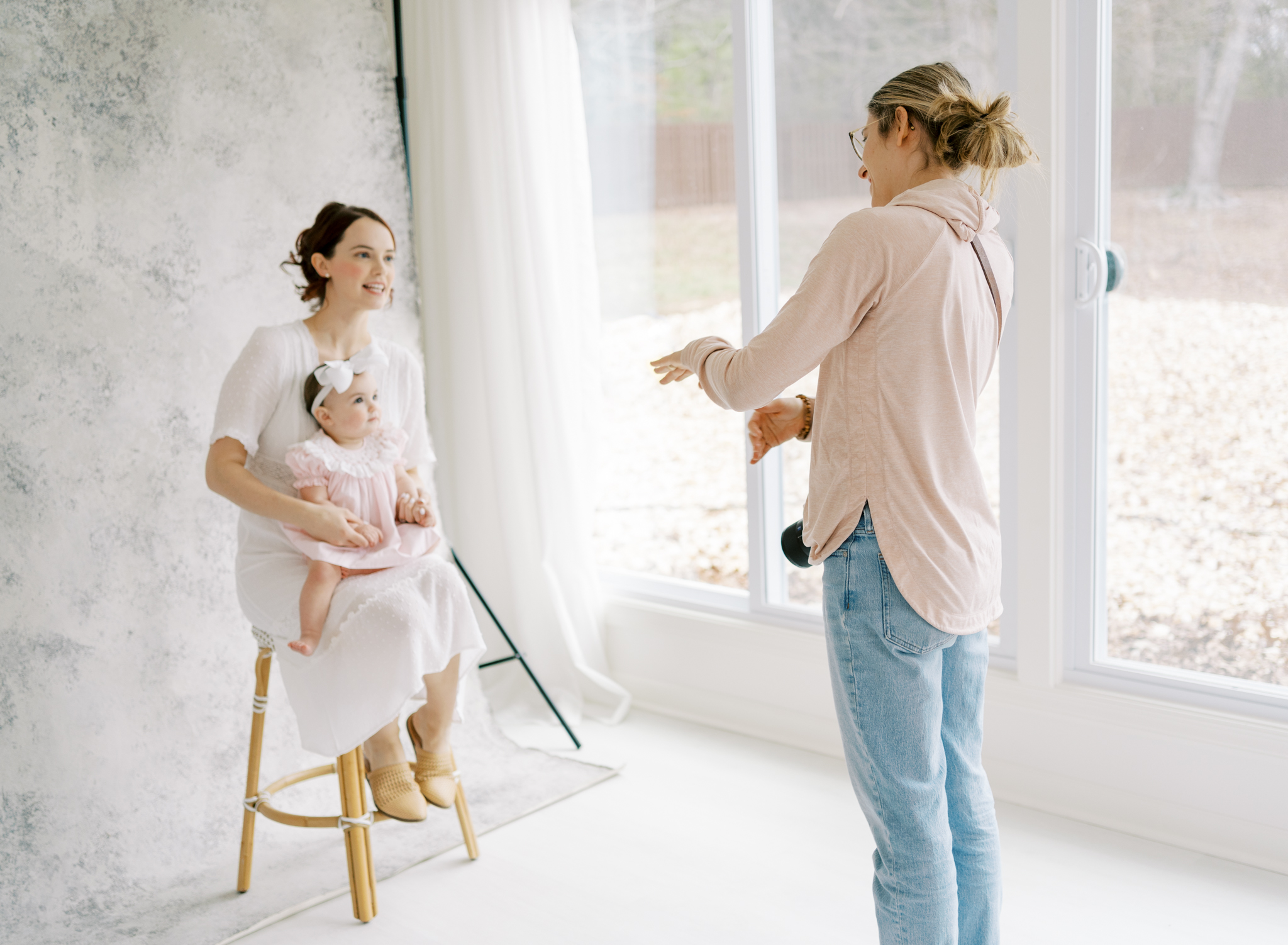 Photographer taking artistic motherhood portrait with painted backdrop in Cumming, GA photography studio