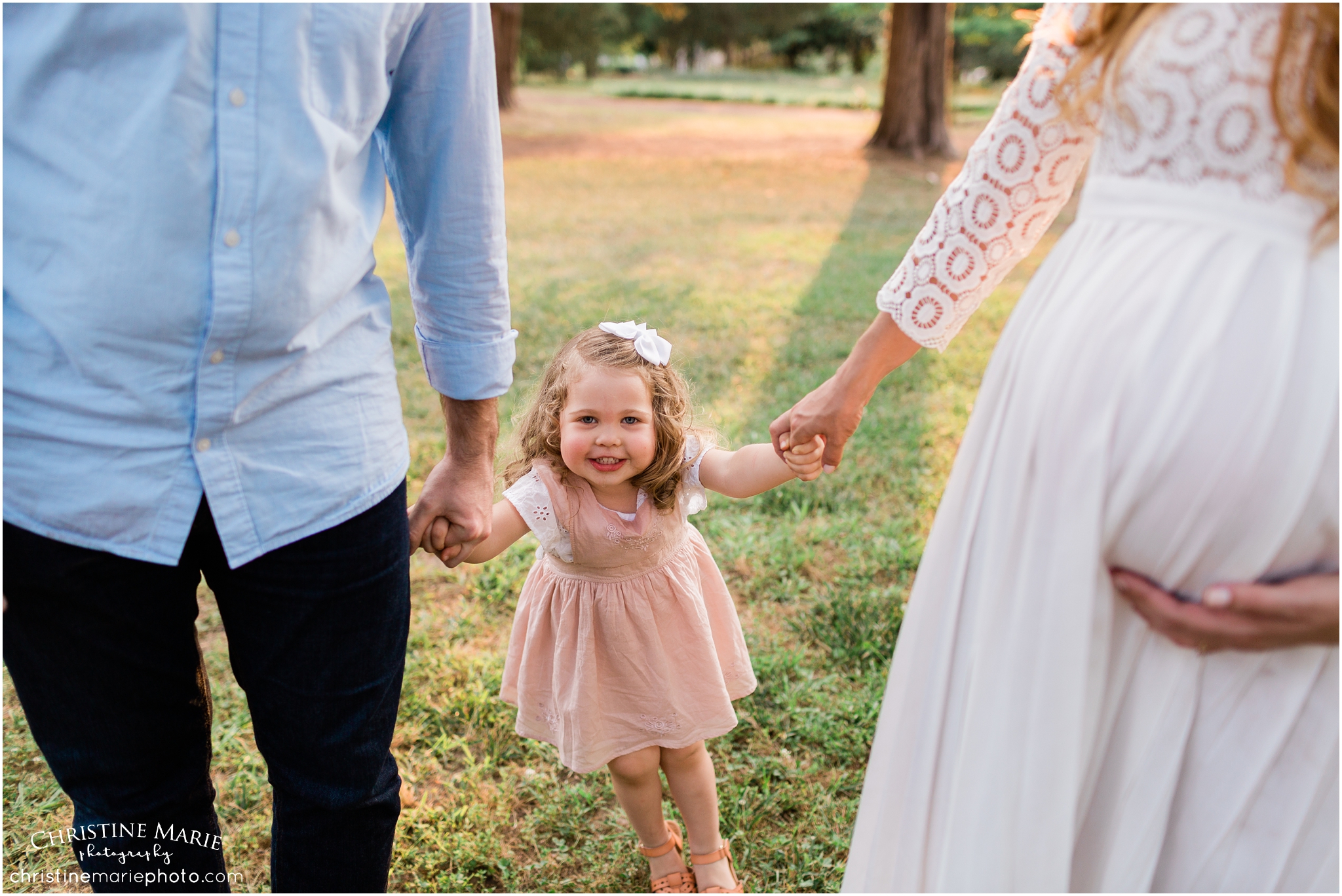 little girl holding parents hands