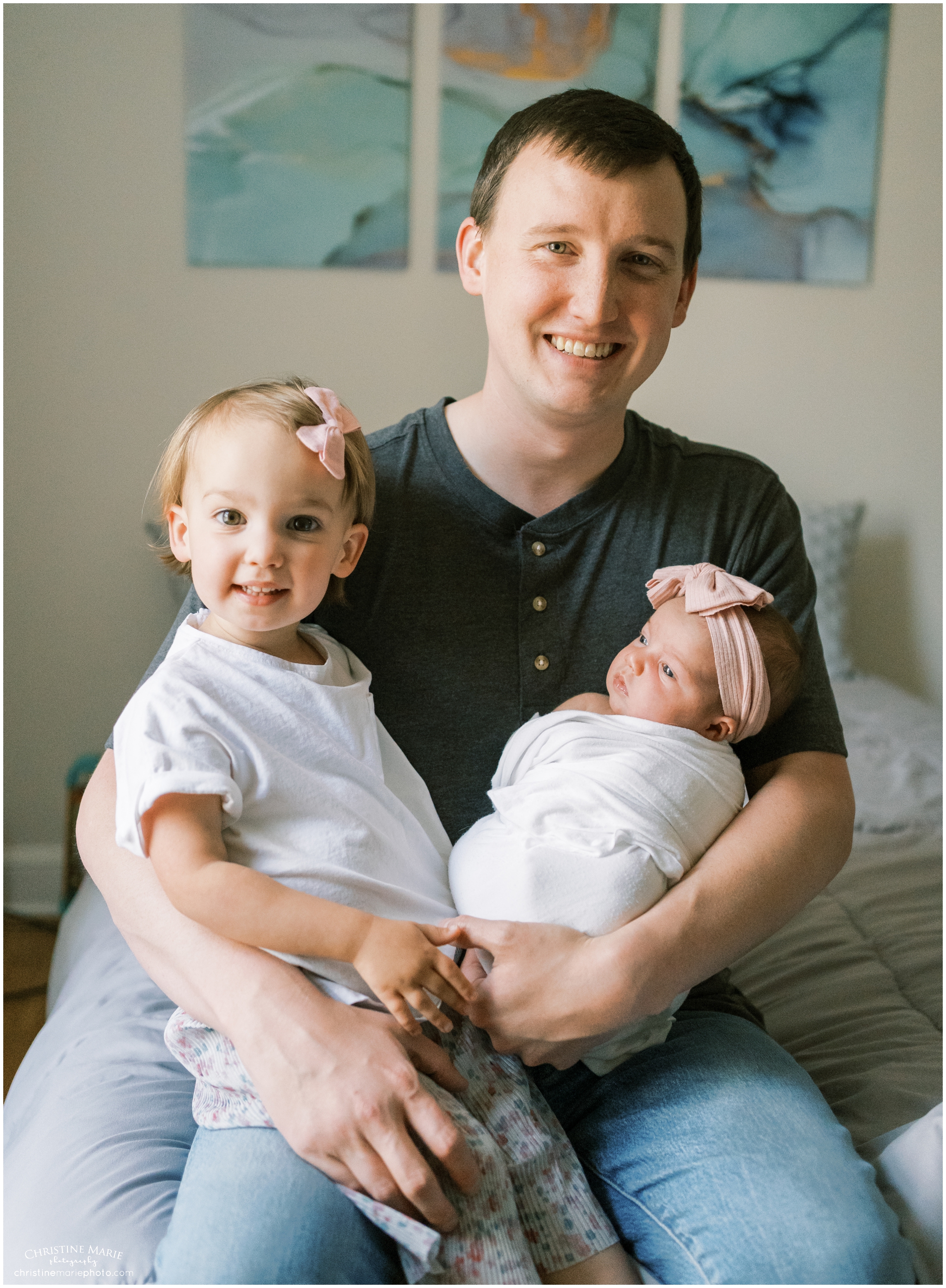 proud dad holding two little girls on his lap