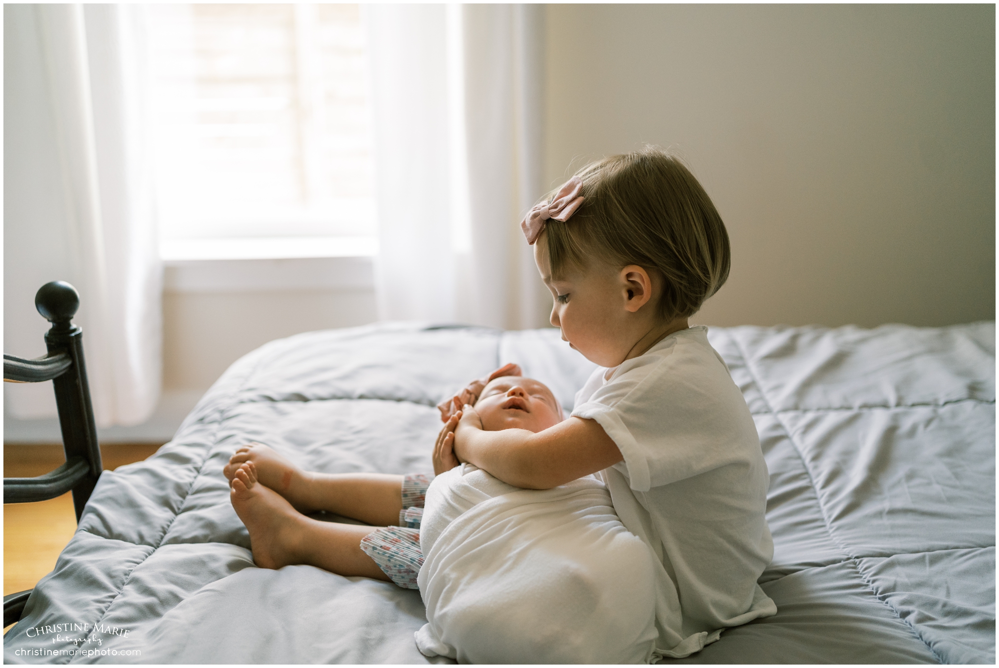 toddler holding new baby sister