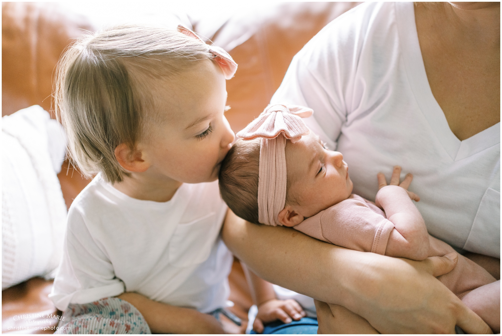 big sister kissing newborn sister in Atlanta lifestyle newborn session