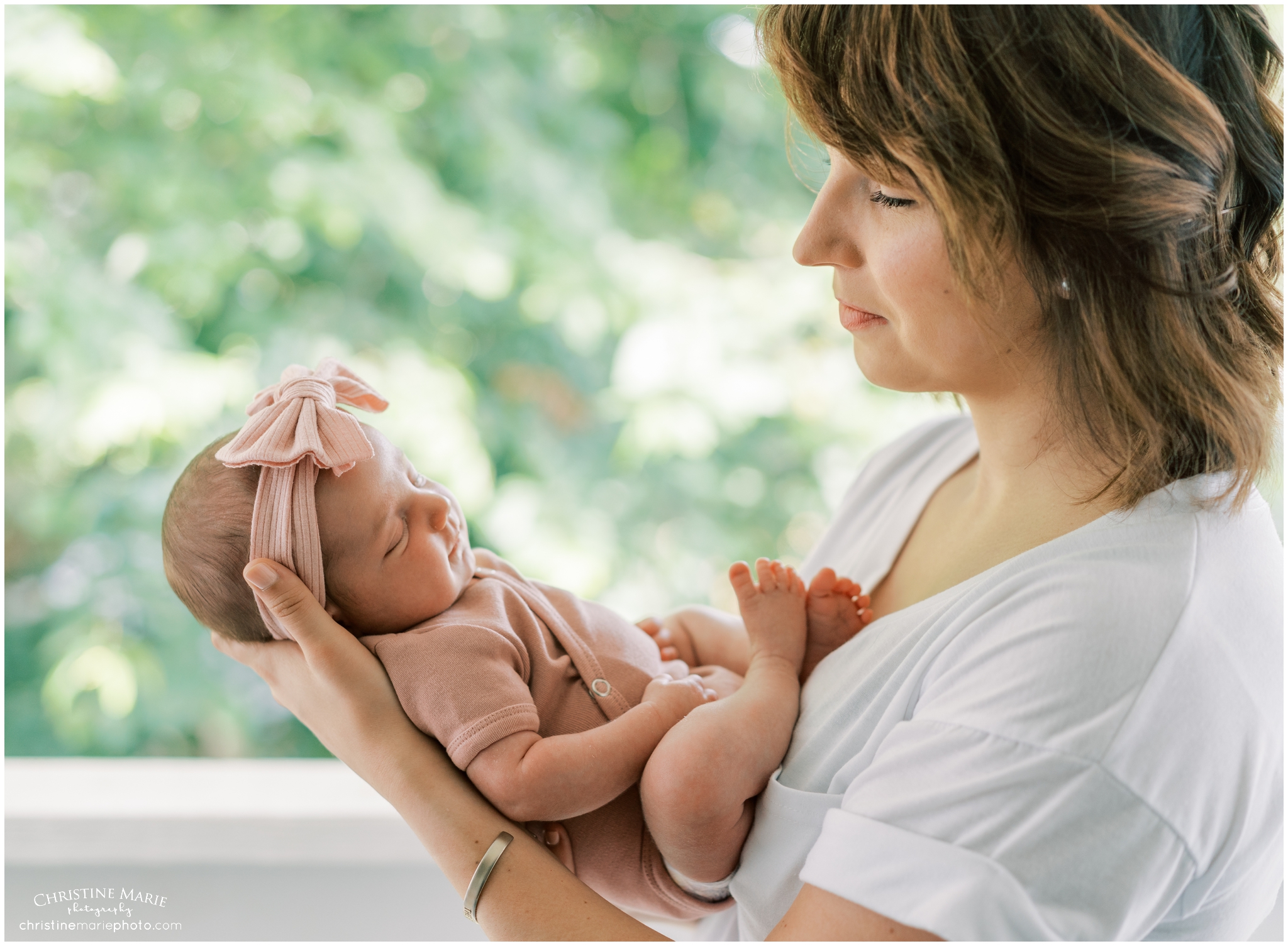 beautiful mom holding smiling newborn baby girl in atlanta home