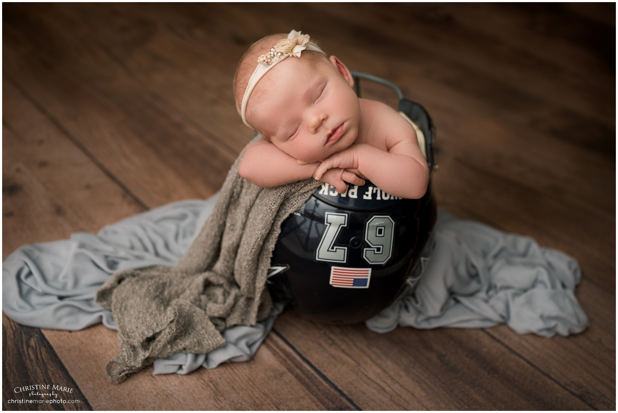 newborn girl in daddy's football helmet in Atlanta studio
