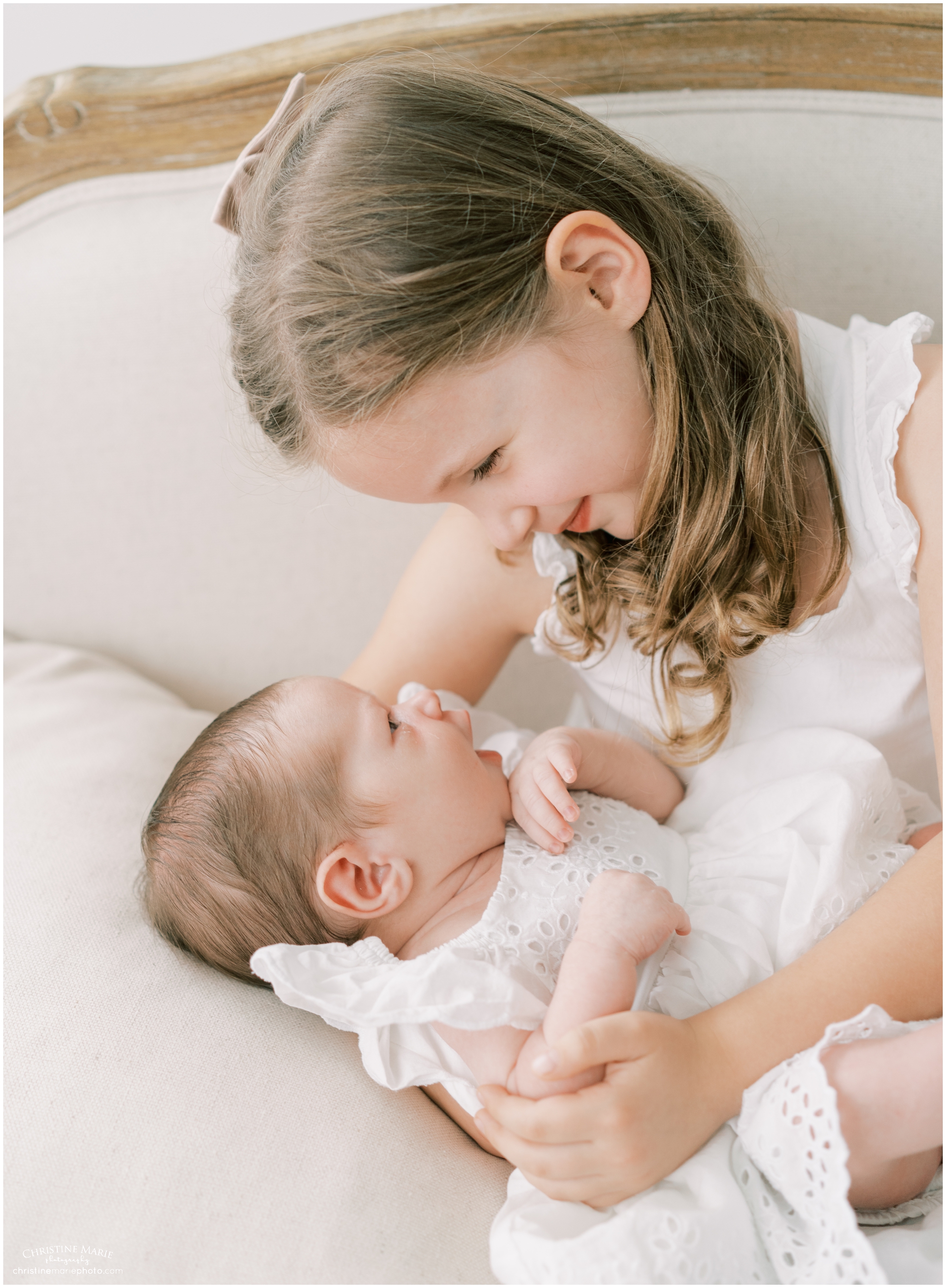 big sister holding baby sister in atlanta photography studio