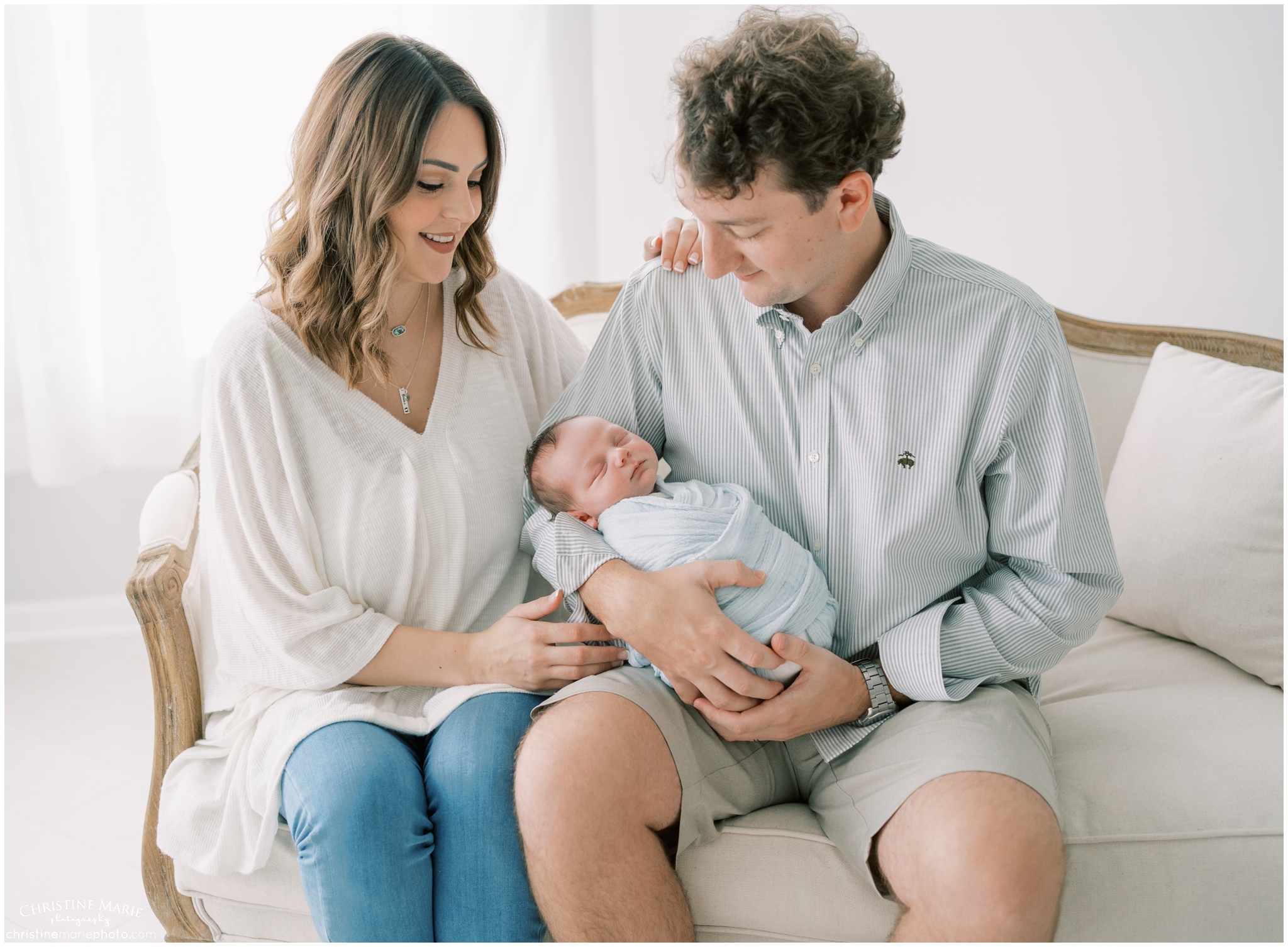 mom and dad holding newborn boy in cumming newborn photography studio