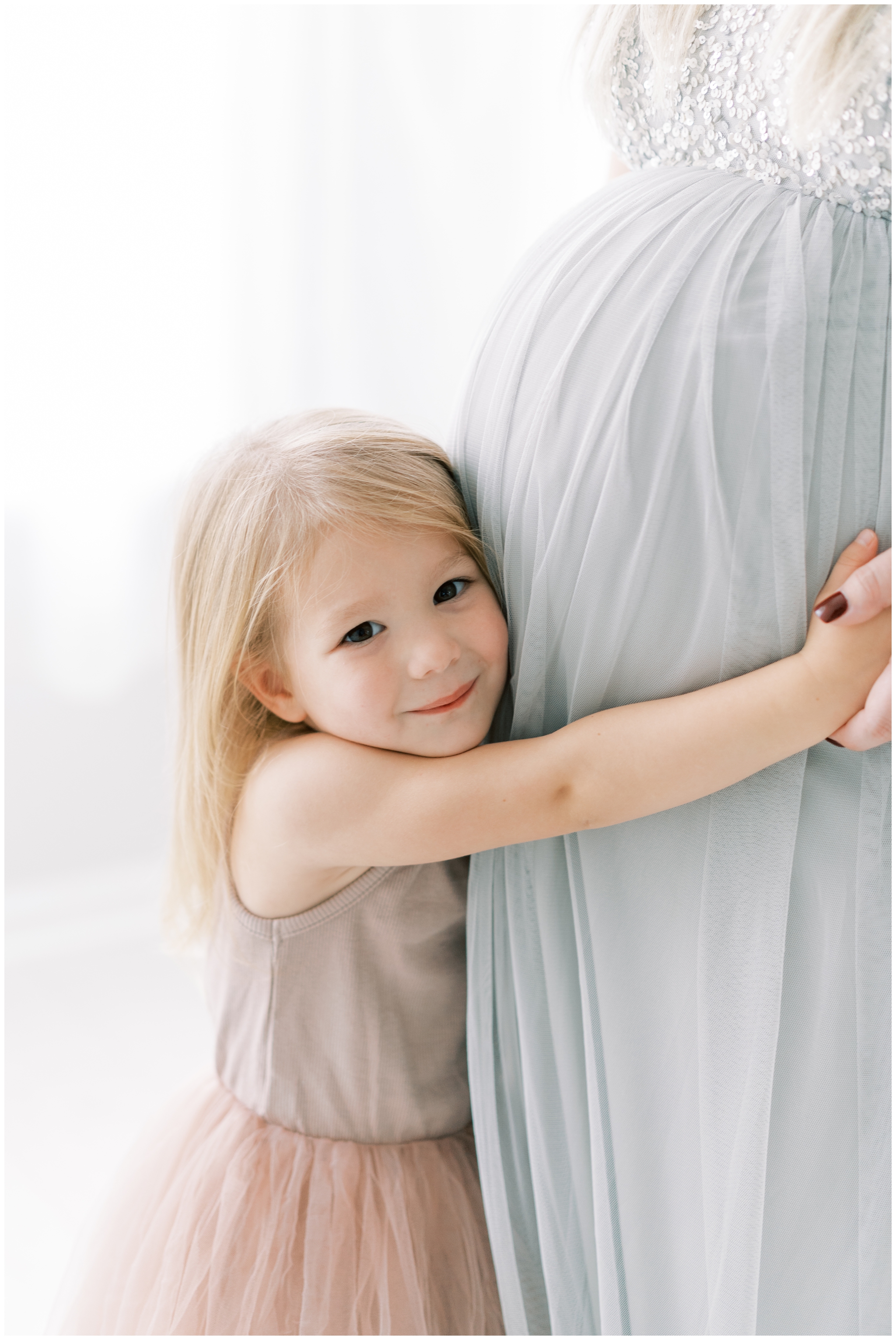 little girl hugging mommy's pregnant belly