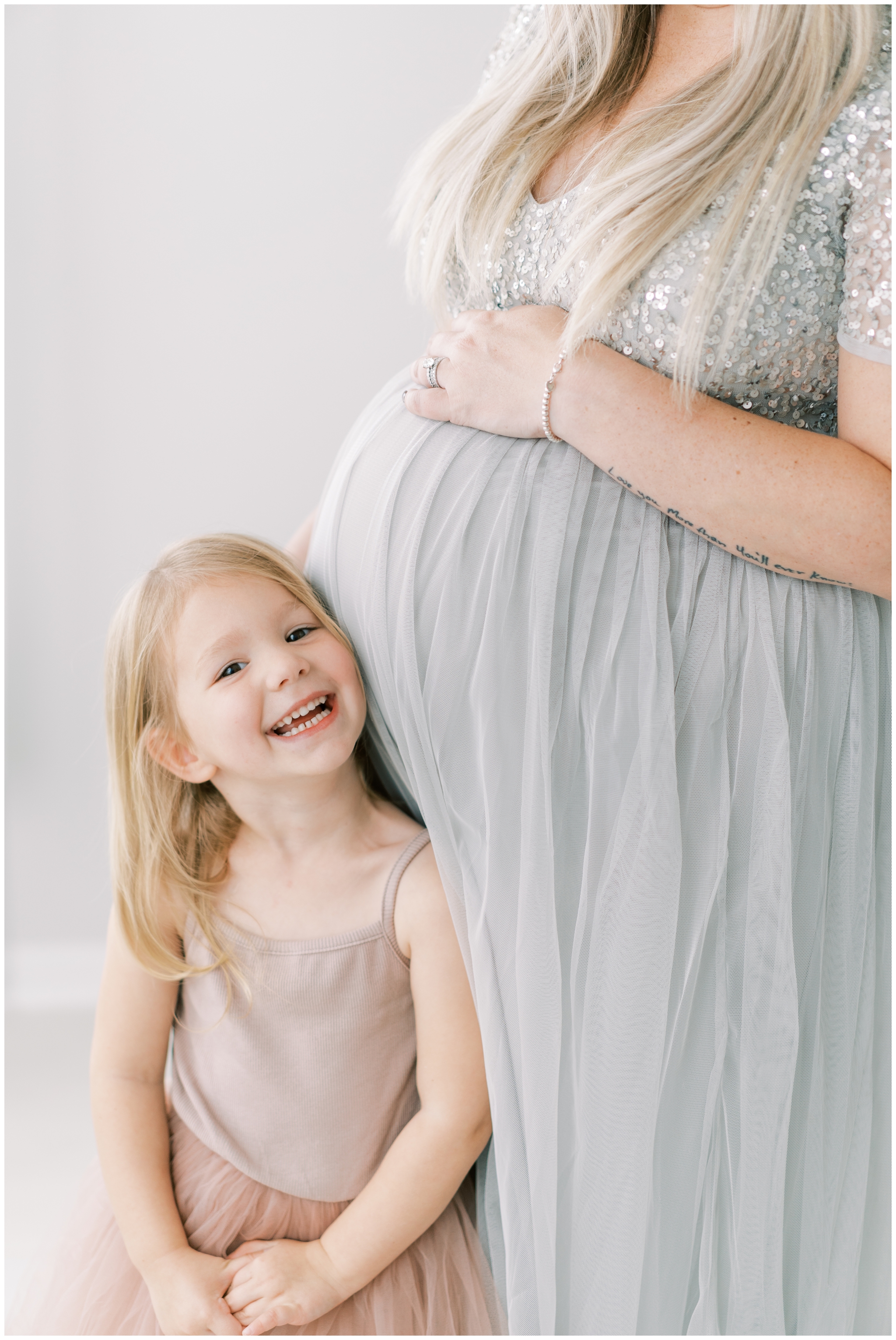 little girl leaning on mommy's pregnant belly