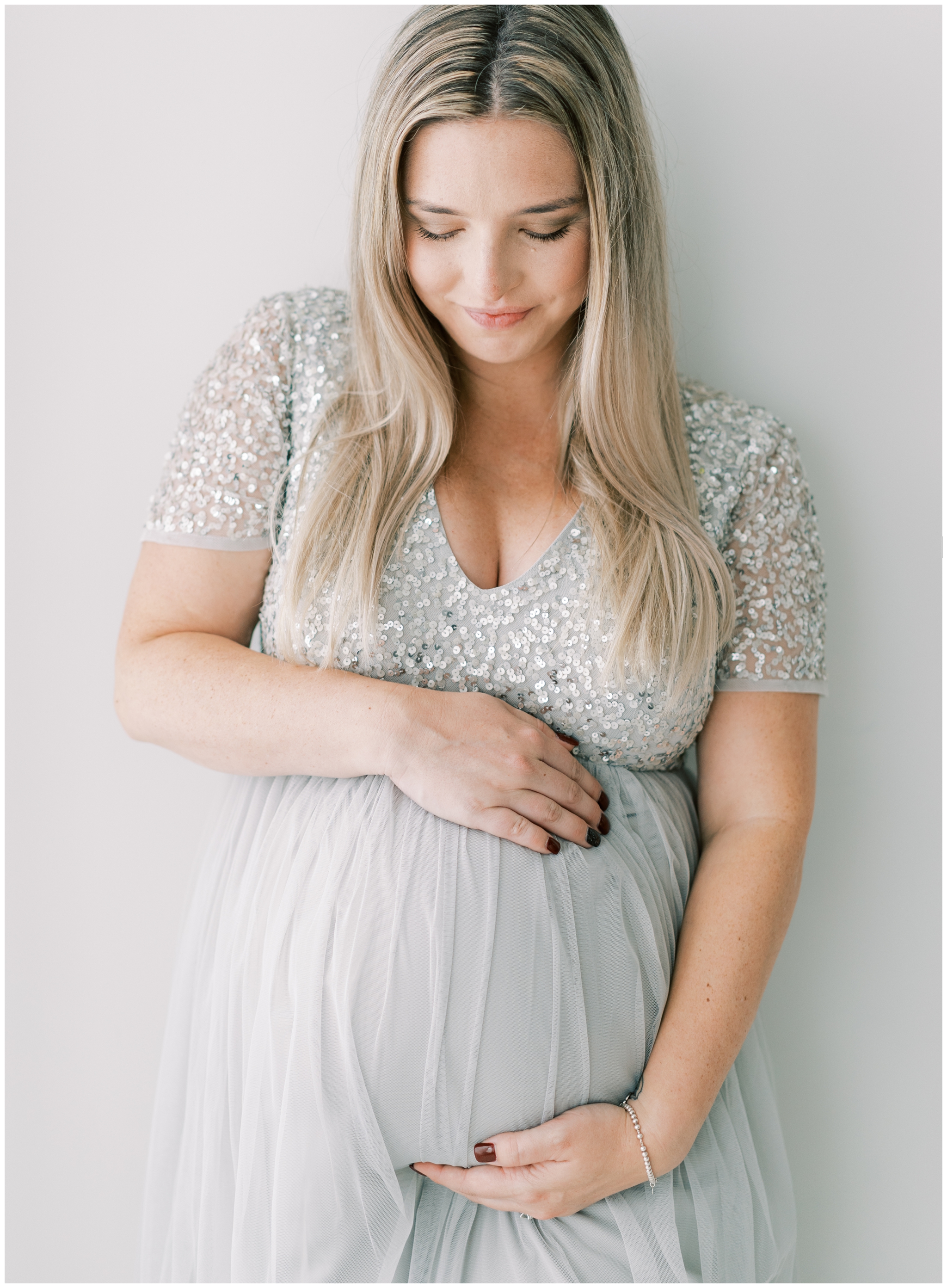 pregnant mom in gown looking down at belly, atlanta studio