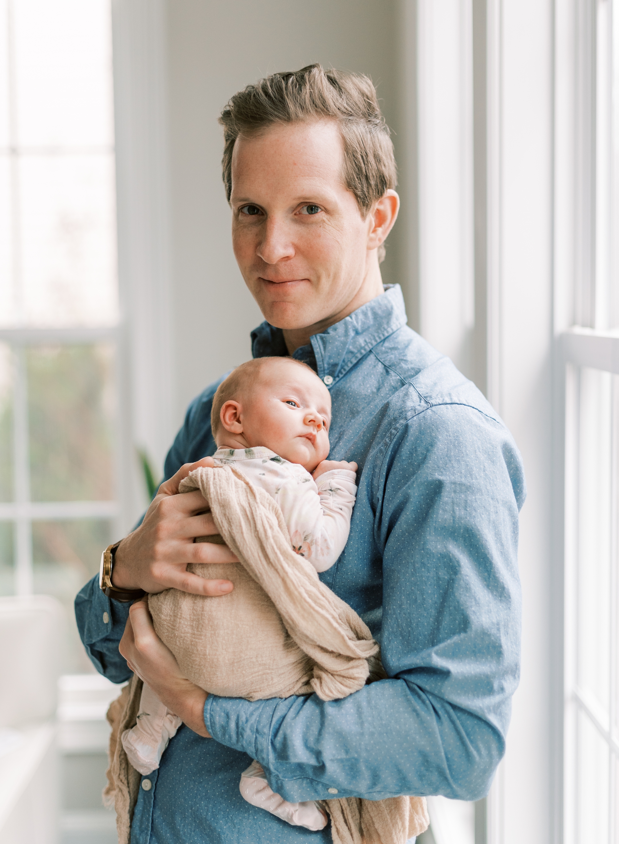 proud dad holding new baby girl in lifestyle newborn session Roswell, GA
