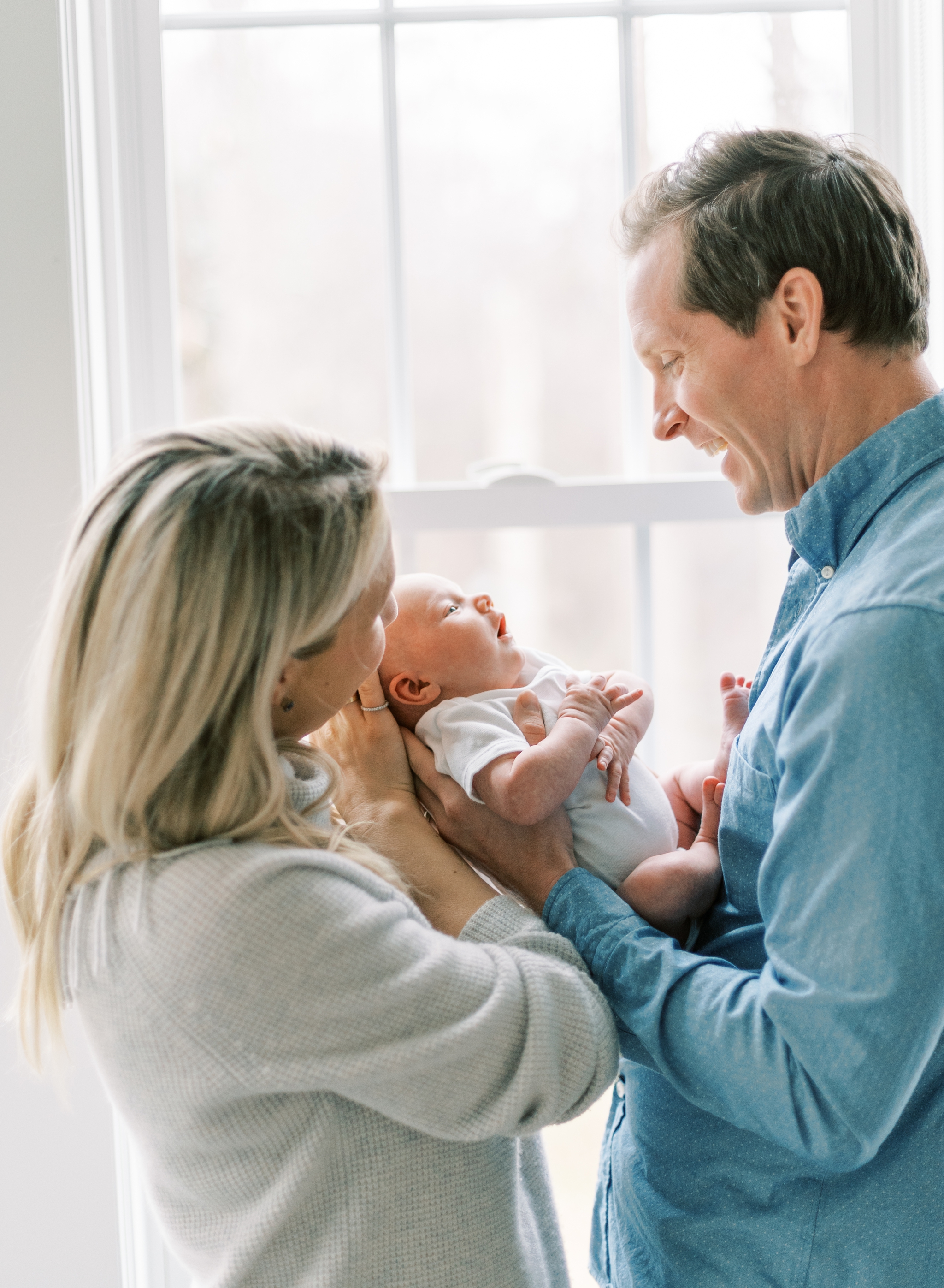 sweet moment with parent and new baby, glowing newborn photography 