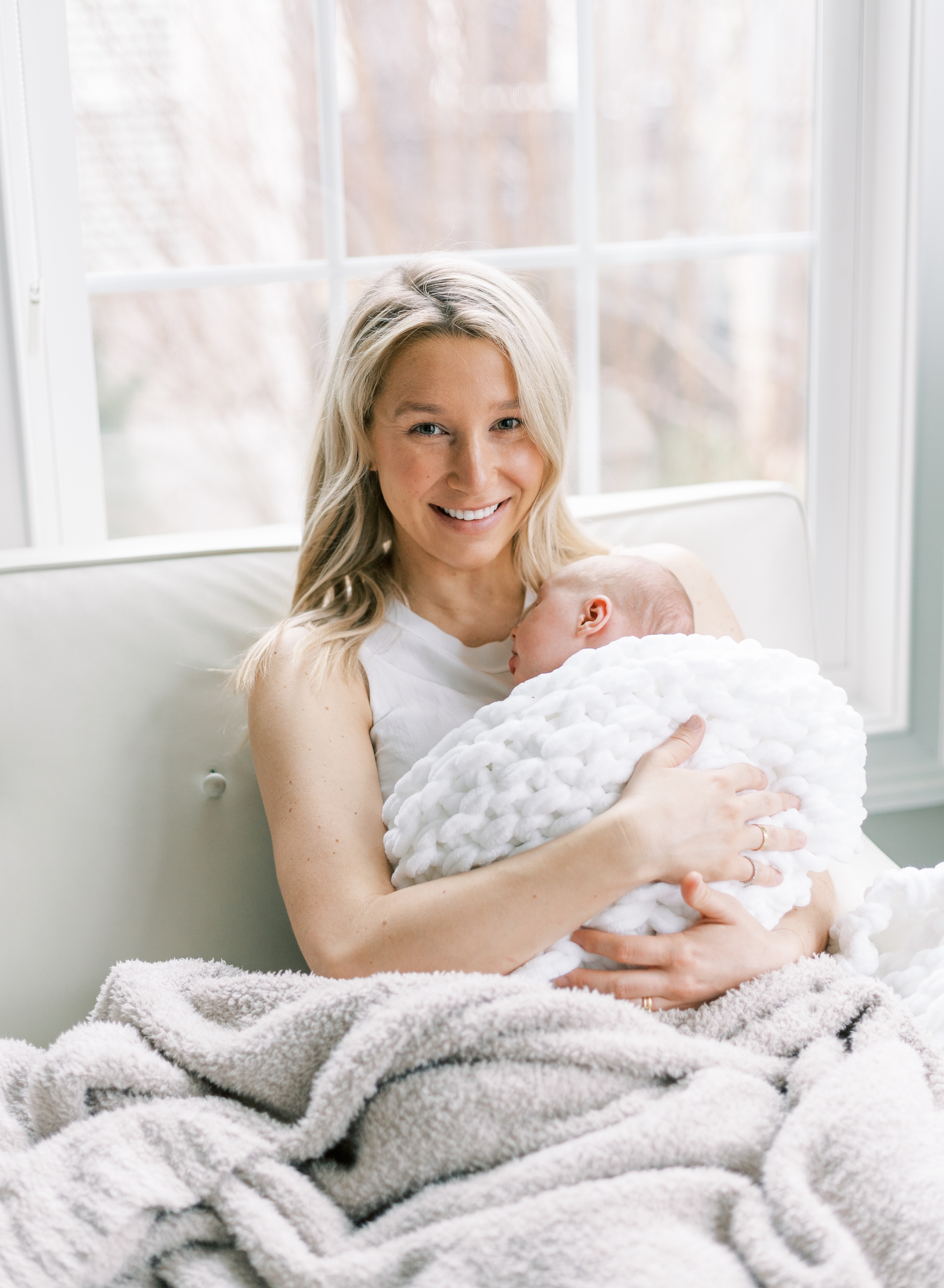 glowing new mom lounging on couch with baby girl