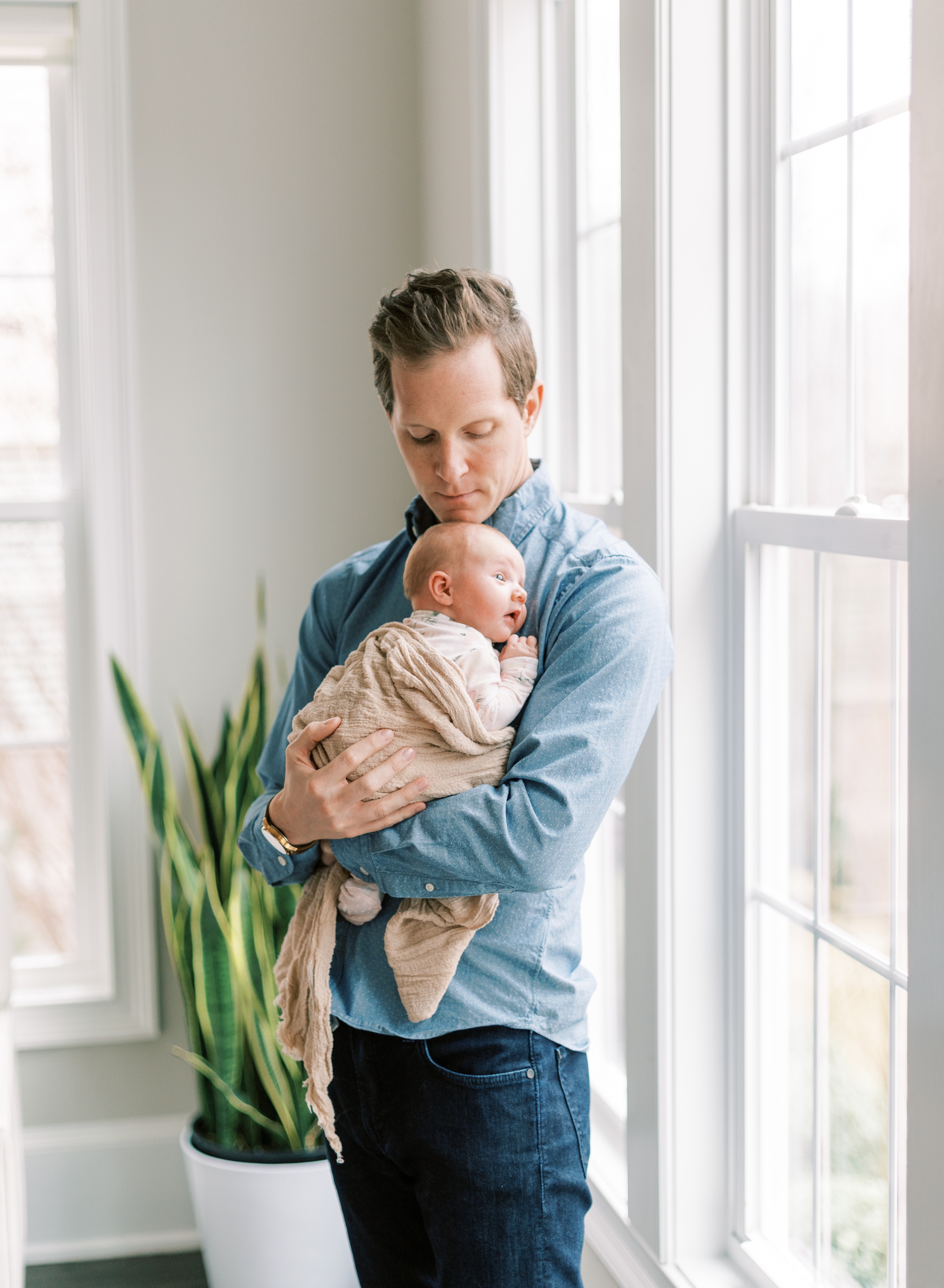 proud dad holding new baby girl in lifestyle newborn session Roswell, GA