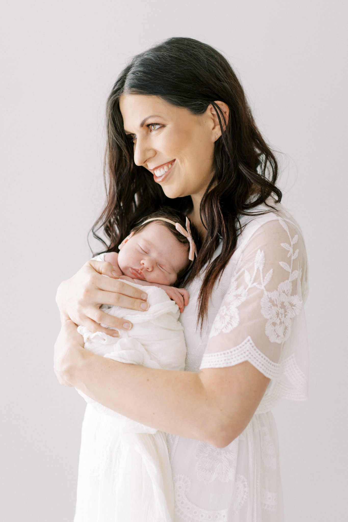 mother holding newborn in cumming newborn photography studio