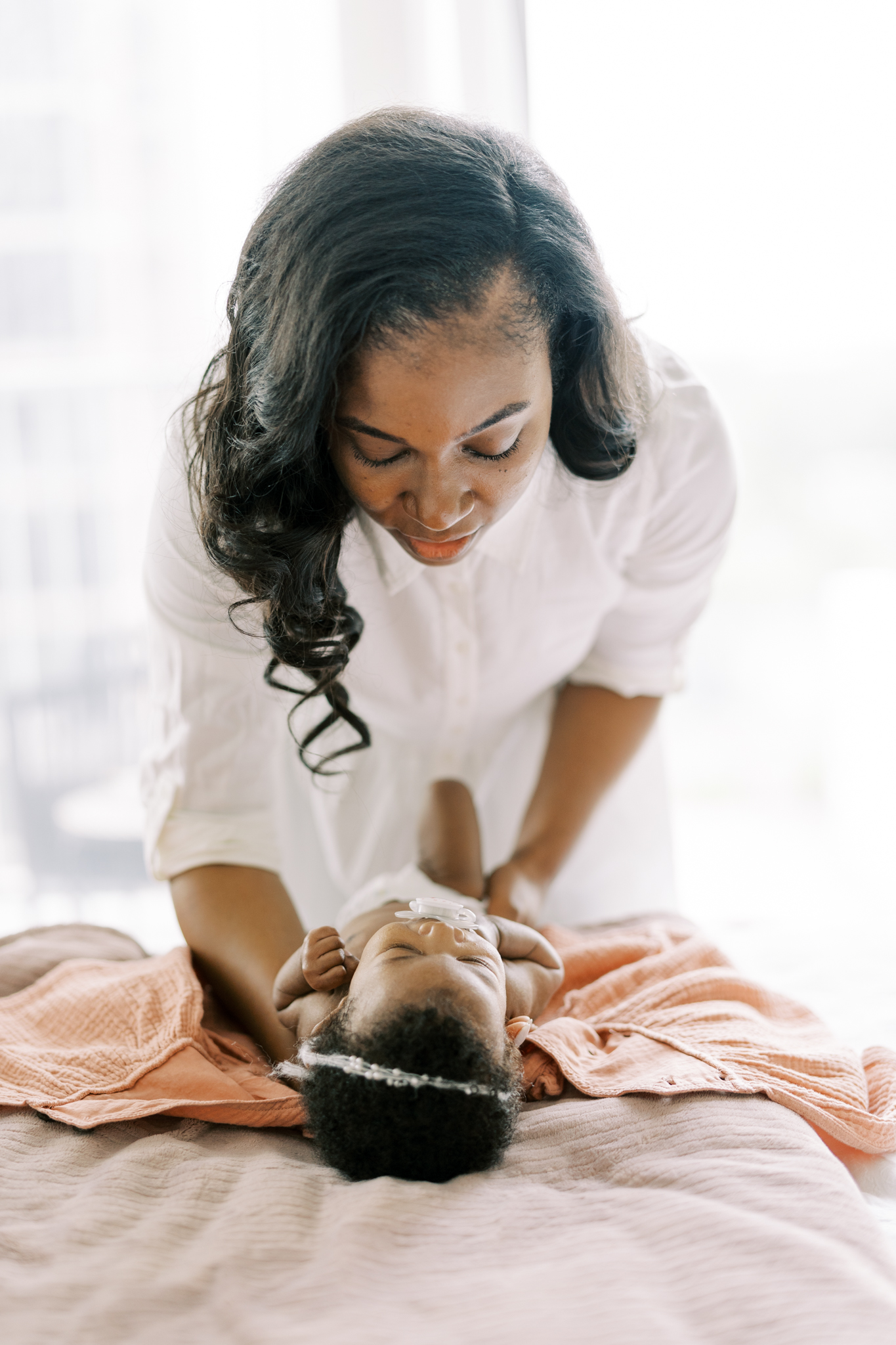 mother changing newborn daughter in sweet moment, atlanta ga