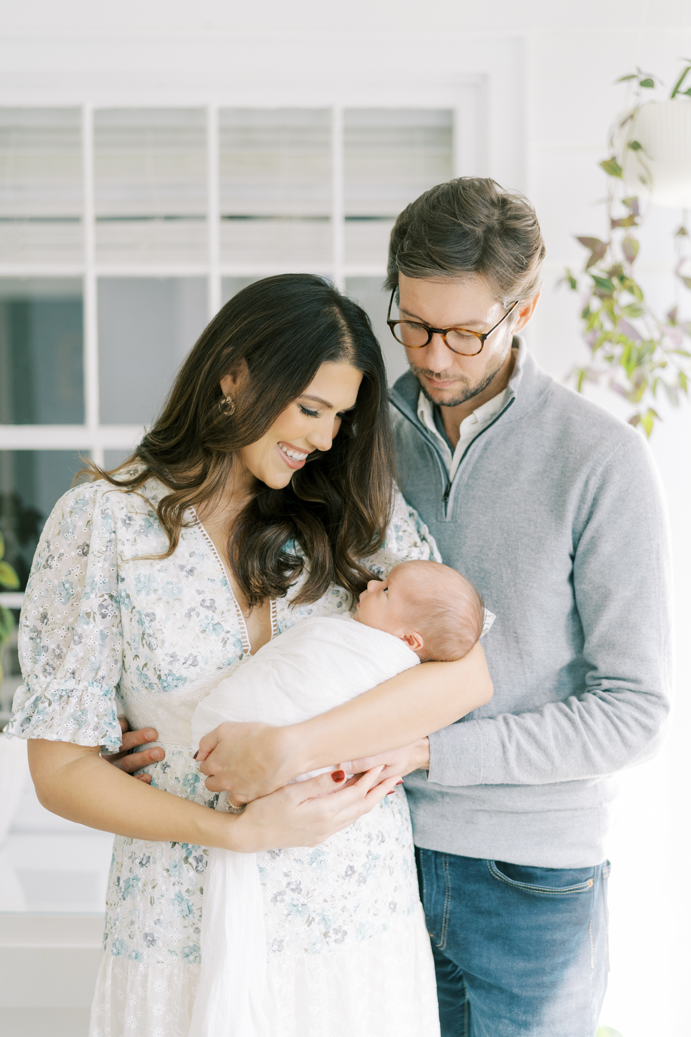 Stylish Atlanta family smiling at the newborn baby boy during a photoshoot at home. Atlanta Lifestyle newborn photographer, Christine Clements.