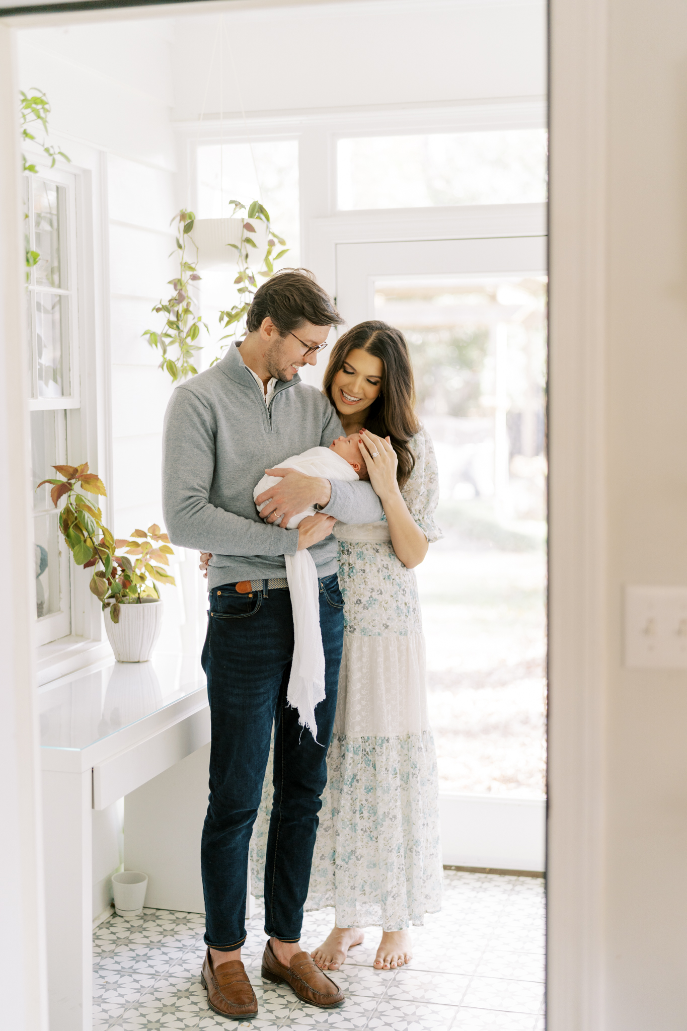 New parents adoring their baby boy in the sunroom of their Atlanta home. 