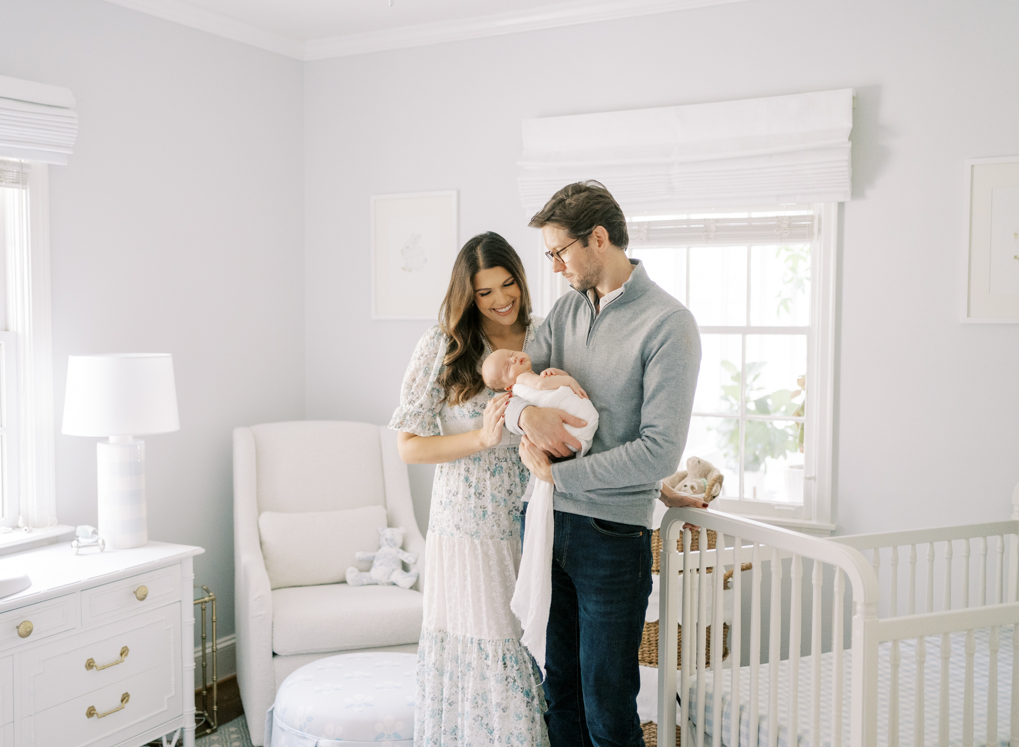 New parents smiling at their baby boy in his classic southern nursery in Atlanta. 