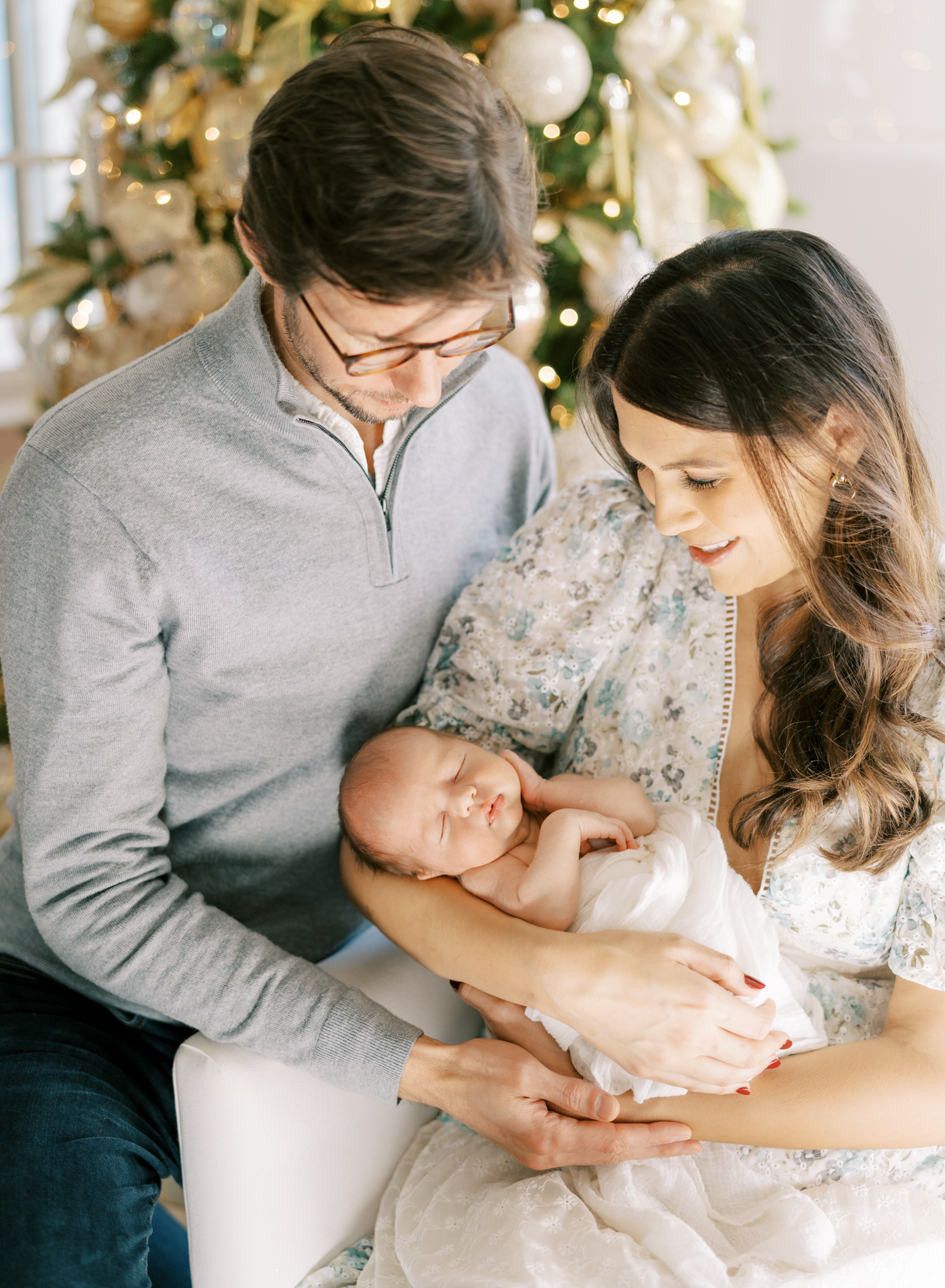 New Atlanta parents holding baby boy before the Christmas tree during photoshoot. 