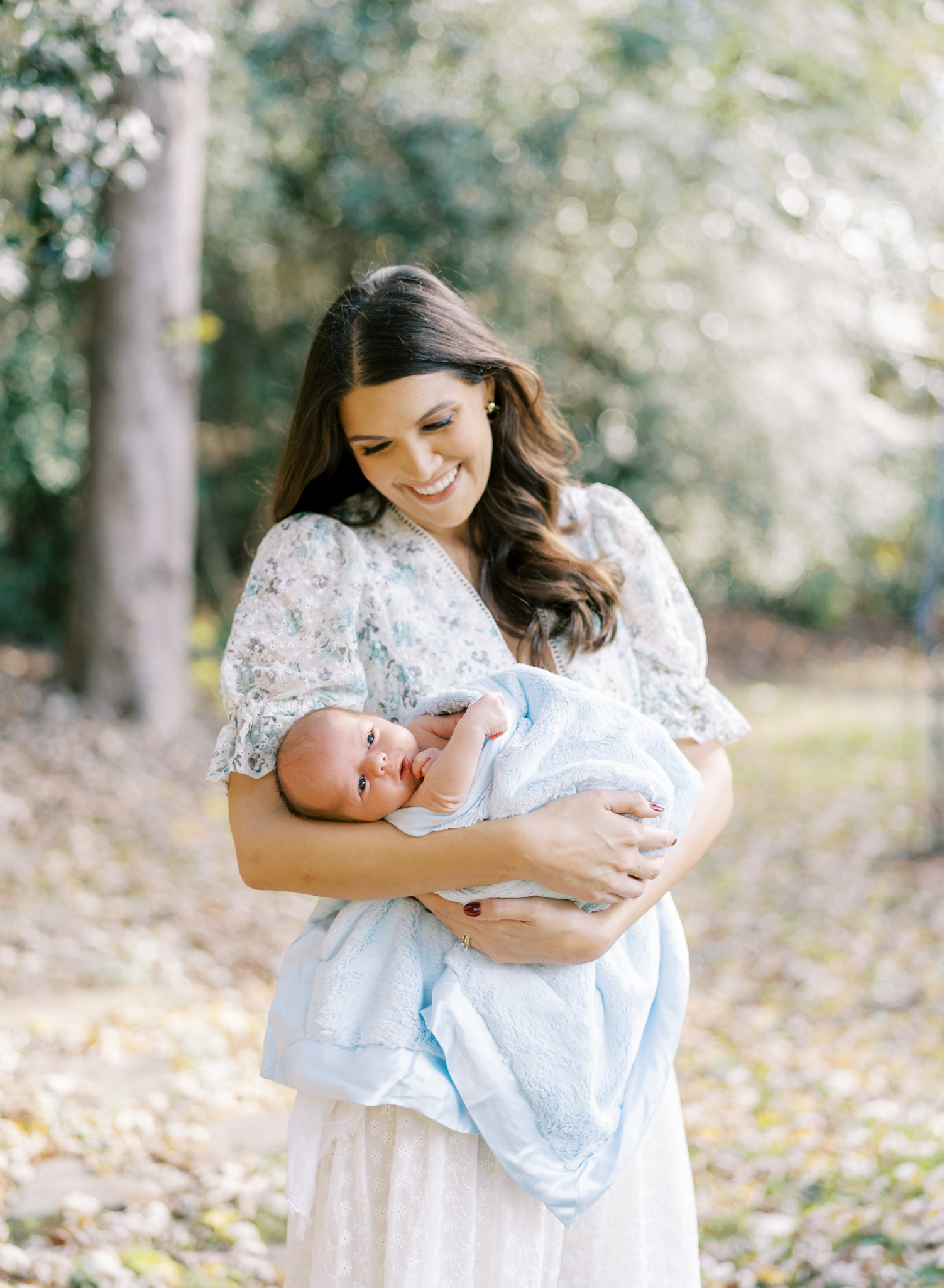 Stunning new mother holding baby boy in her Atlanta backyard.