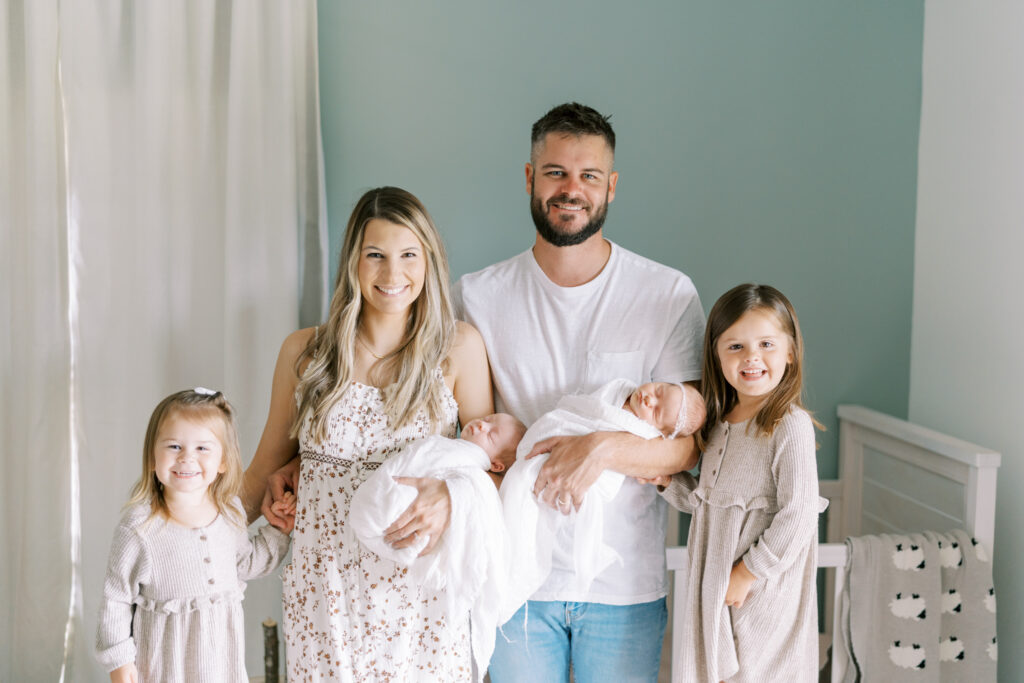 Happy family holding their newborn twins for lifestyle newborn session in Cumming GA.