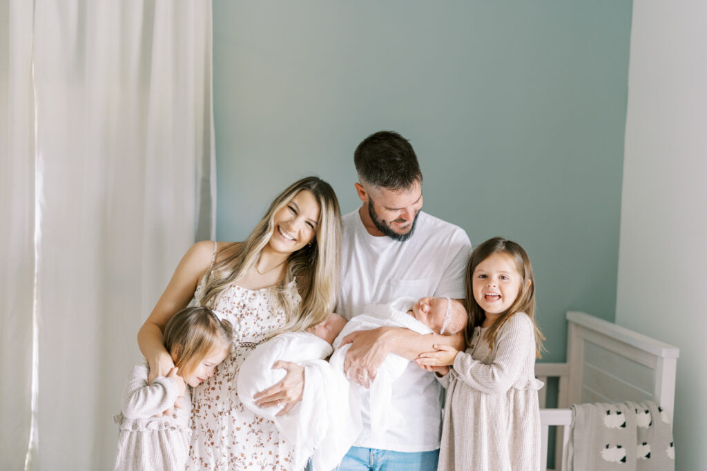 Happy family with newborn twins posed for lifestyle newborn photos in North GA.