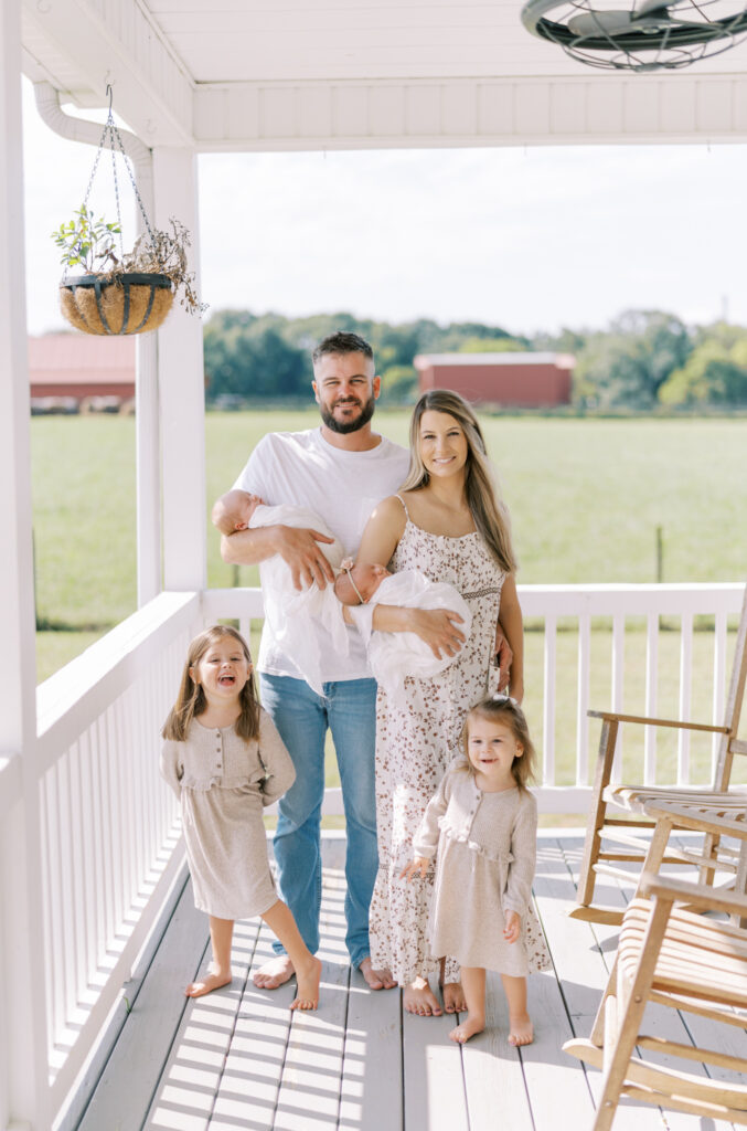 Family posed on their front porch for newborn and family photos in North GA