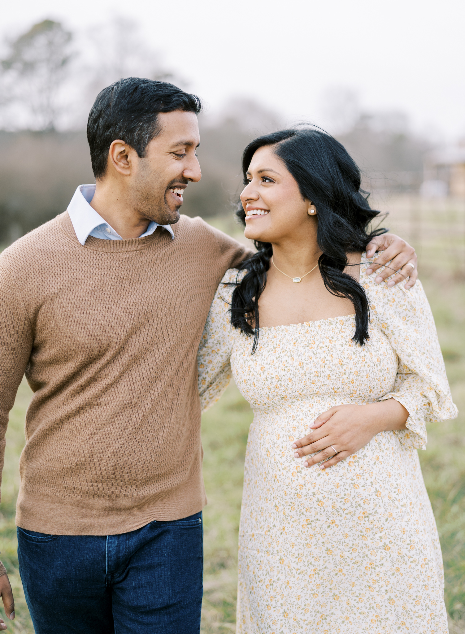 expecting parents smiling at each other and walking