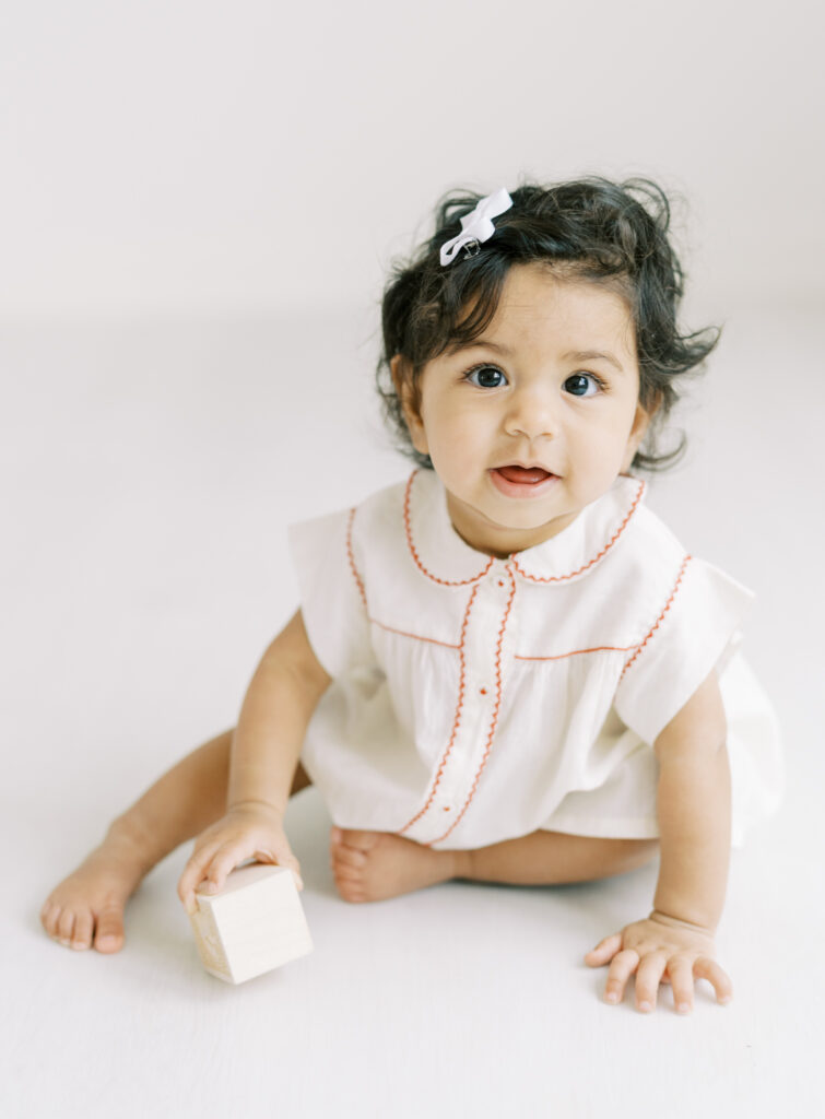 6 month baby girl in clean white studio for a natural portrait.