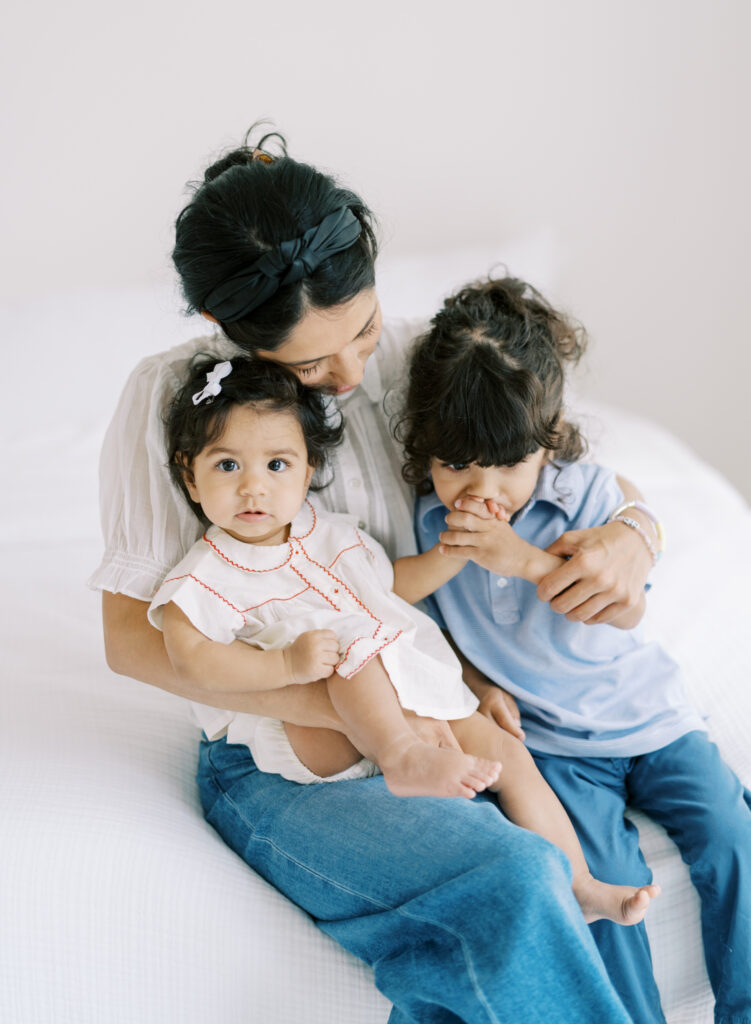 Candid moment of mom snuggling up her two children in Atlanta, GA photography studio.